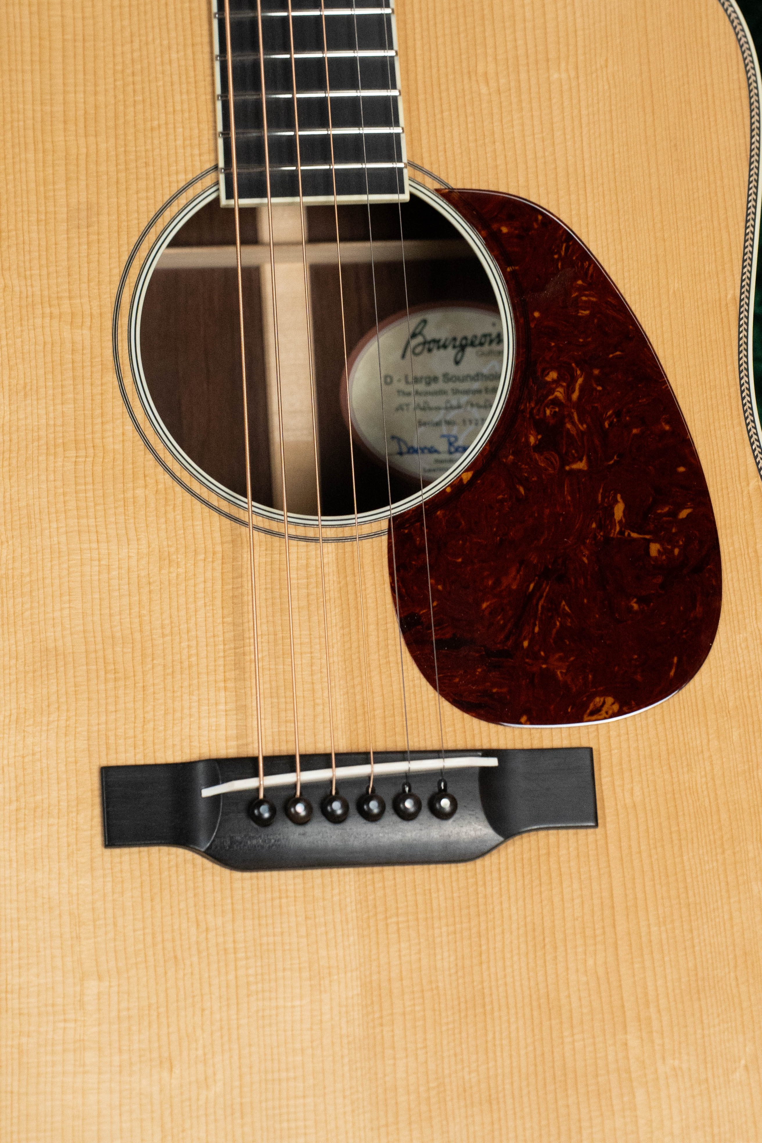 A close-up of the Bourgeois TAS LSH Professional Series Satin Dreadnought Guitar highlights the sound hole, strings, pickguard, and bridge. The Bourgeois label is partially visible inside. *Pre-Order 25% Deposit ONLY.*.