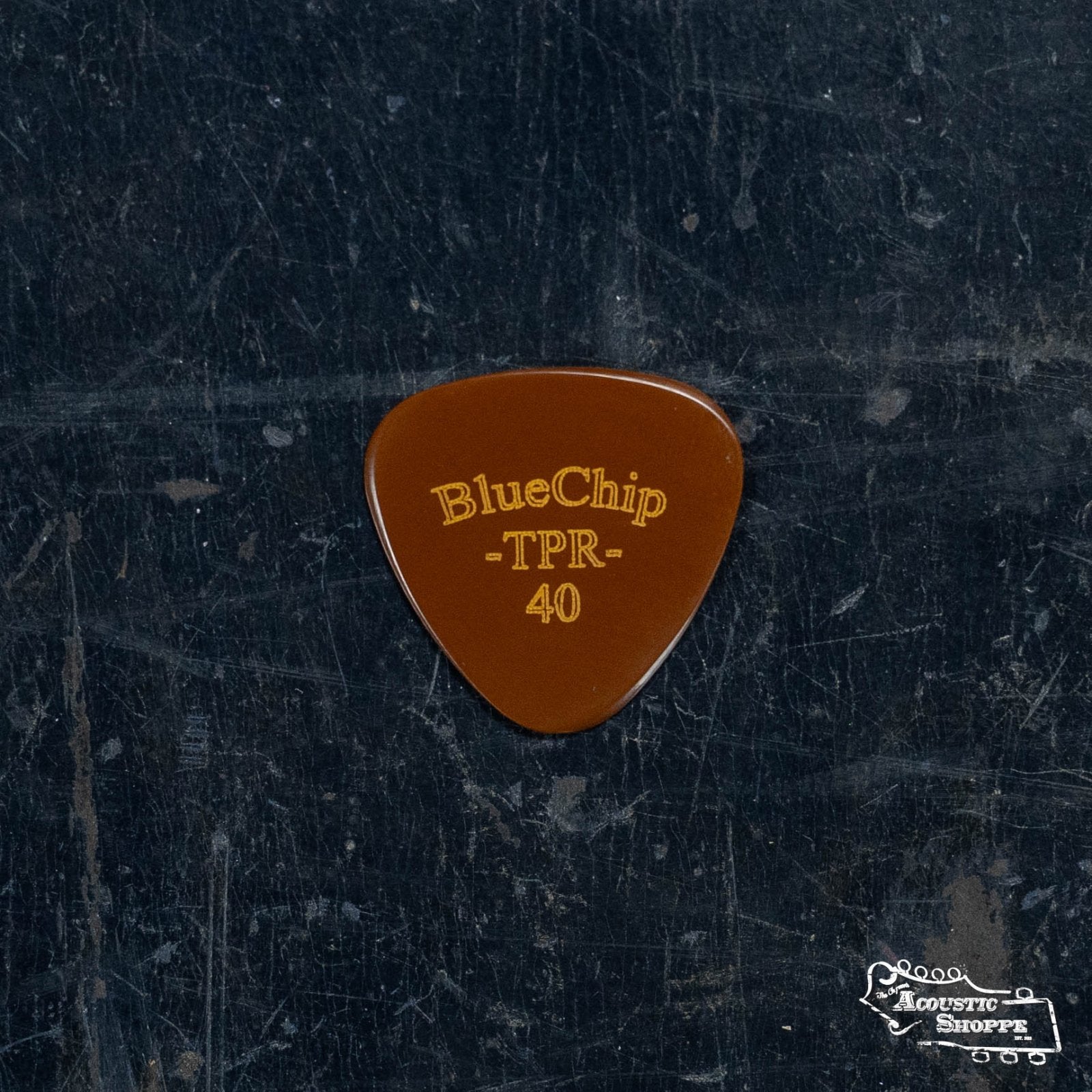 A brown BlueChip Picks (TPR40) by BlueChip, with TPR 40 in yellow, rests on a scratched dark surface. The Acoustic Shoppe logo is in the lower right corner.
