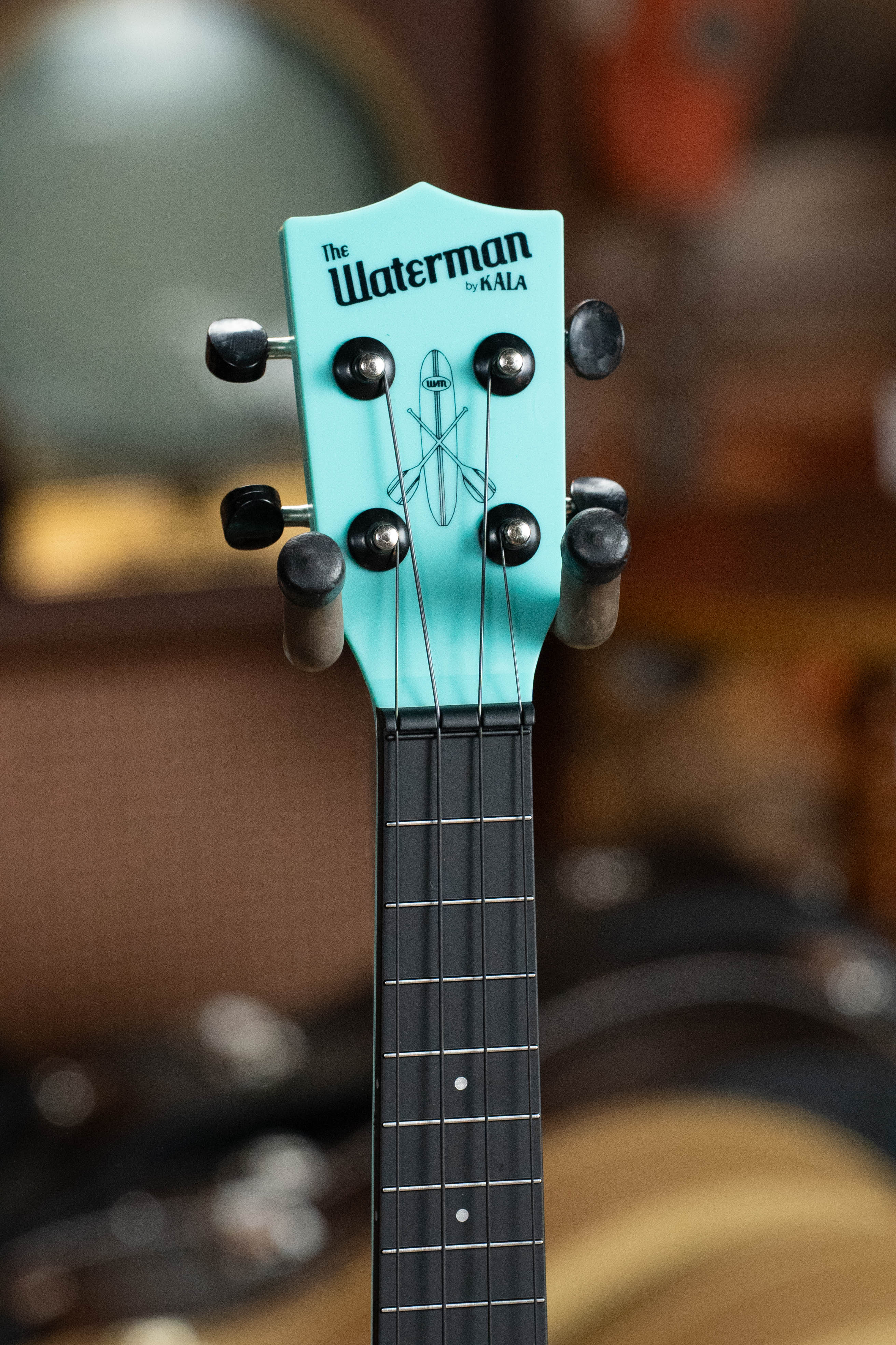 Aqua blue soprano ukulele headstock with black tuning pegs and Waterman USA logo. - The Waterman Aqua Mist Glow-In-The-Dark Soprano Recycled Ukulele - Kala Brand - Default Title
