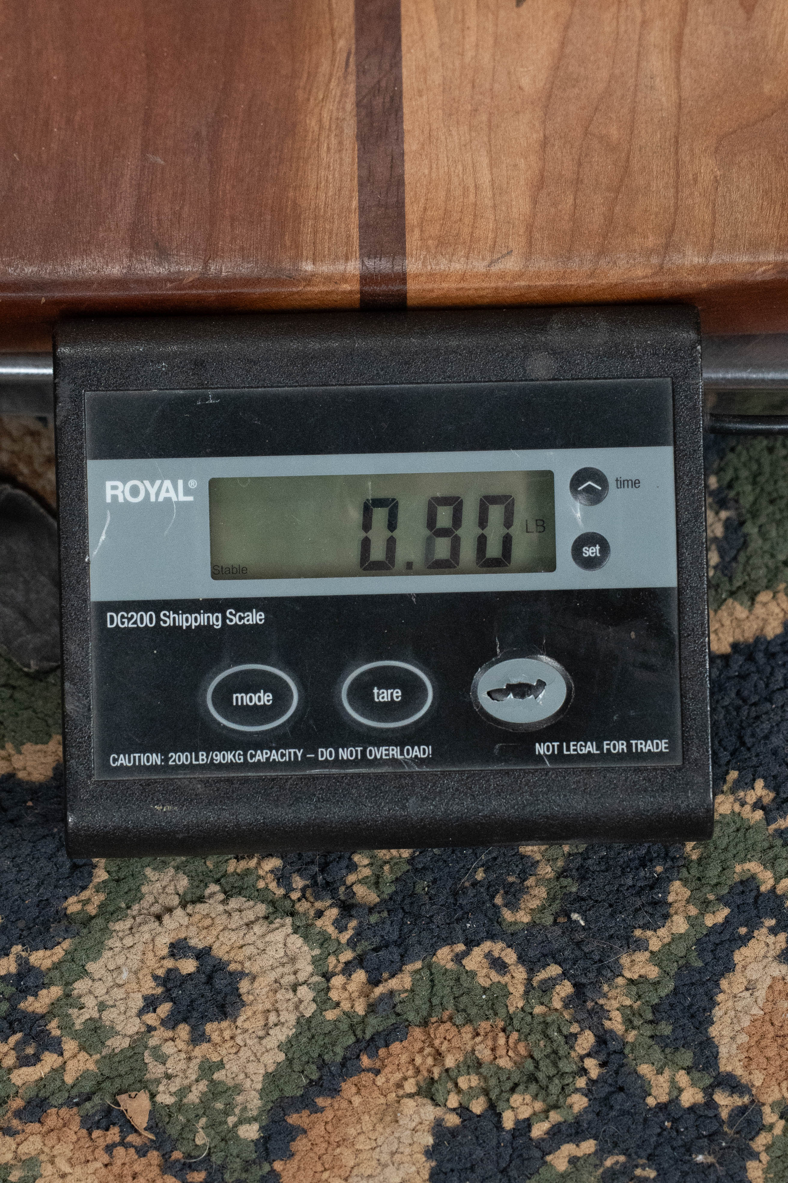 Digital scale displaying a weight of 0.80 pounds on a patterned carpet background. - The Waterman Sunset Orange Soprano Recycled Ukulele - Kala Brand - Default Title