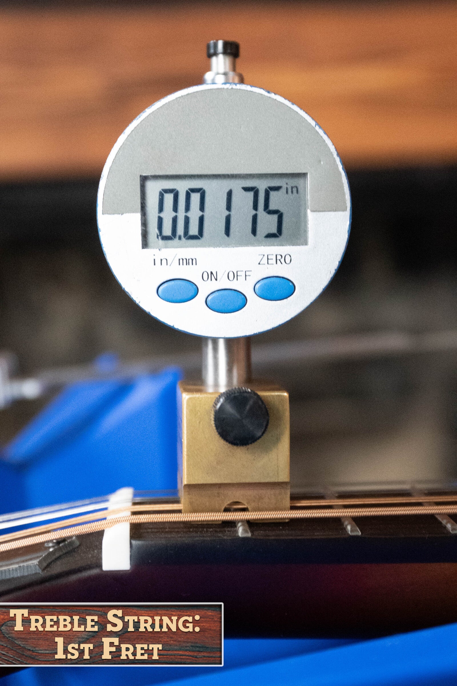 A digital gauge reads 0.0175 inches above the first fret of a guitar treble string, similar to setup checks for The Loar LM-310F-BRB Honey Creek F-Style Brownburst Mandolin #0069 by The Loar; gauge labeled: Treble String: 1st Fret.