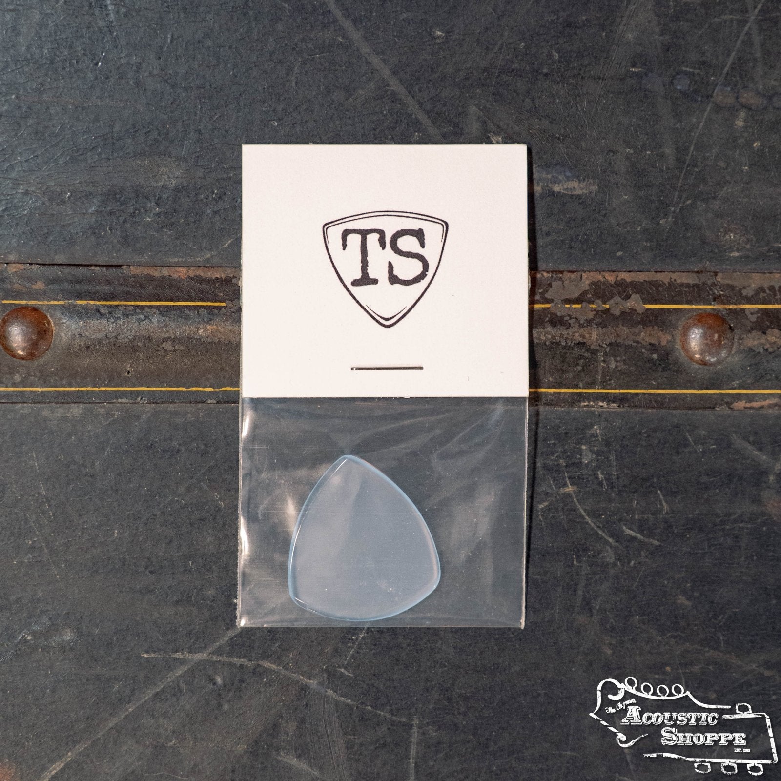 The ToneSlabs Oh Eight Pointed Jazz Guitar Pick (1.4 mm) comes in a plastic sleeve on a card with the “TS” logo, both displayed on a worn dark surface with The Acoustic Shoppe logo at the bottom right.
