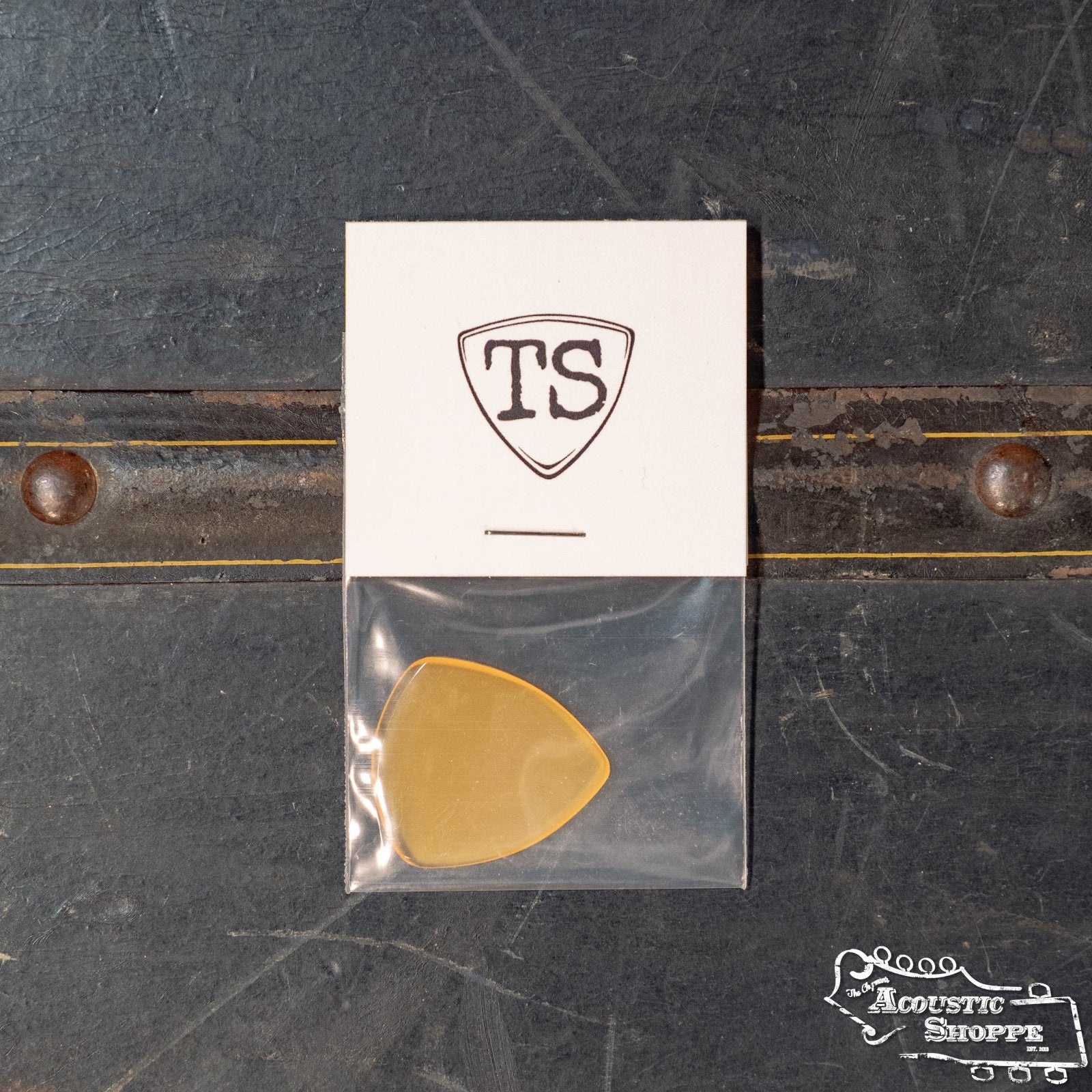 The ToneSlabs Oh Eight Pointed Jazz Guitar Pick (1.5 mm) by ToneSlabs is shown in a small clear bag on a white card with the TS logo, displayed atop The Acoustic Shoppe logo. Ideal for enhancing your instrument’s tone.