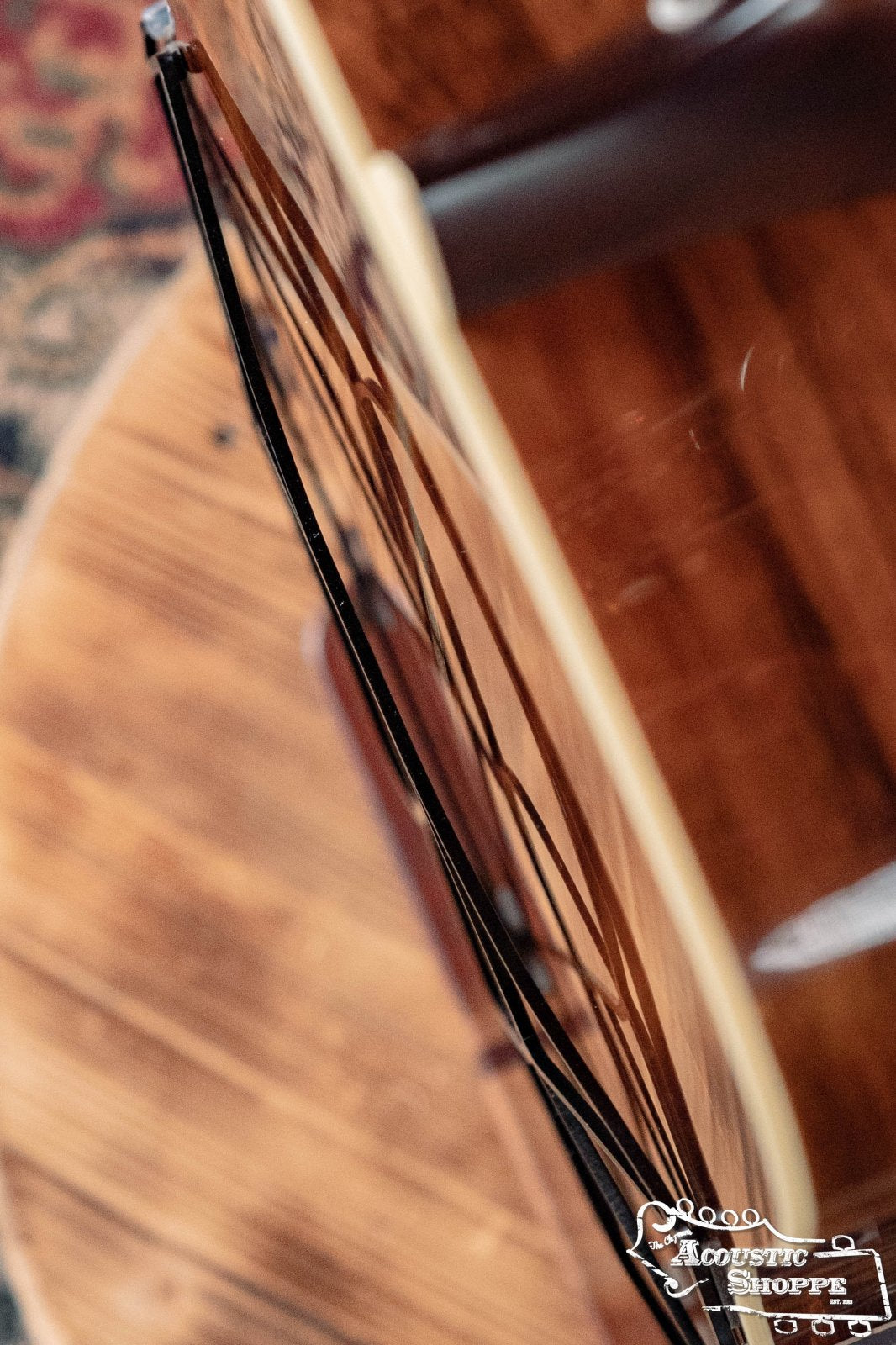 Top-down view of an acoustic guitar with a warped or cracked side on wood. The Acoustic Shoppe logo appears, featuring the Tone-Gard Dreadnaught Guitar D-Gard by Tone-Gard to enhance your instrument’s tone.