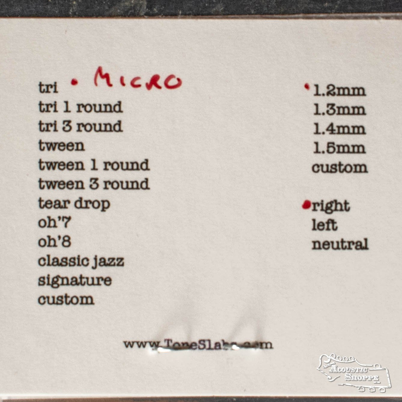 A printed list of guitar pick shapes and thicknesses features Micro handwritten in red next to tri, highlighting the ToneSlabs Darth Tone Series Tri Micro 1.2mm. Thicknesses range from 1.2mm to custom, with ToneSlabs.com at the bottom.