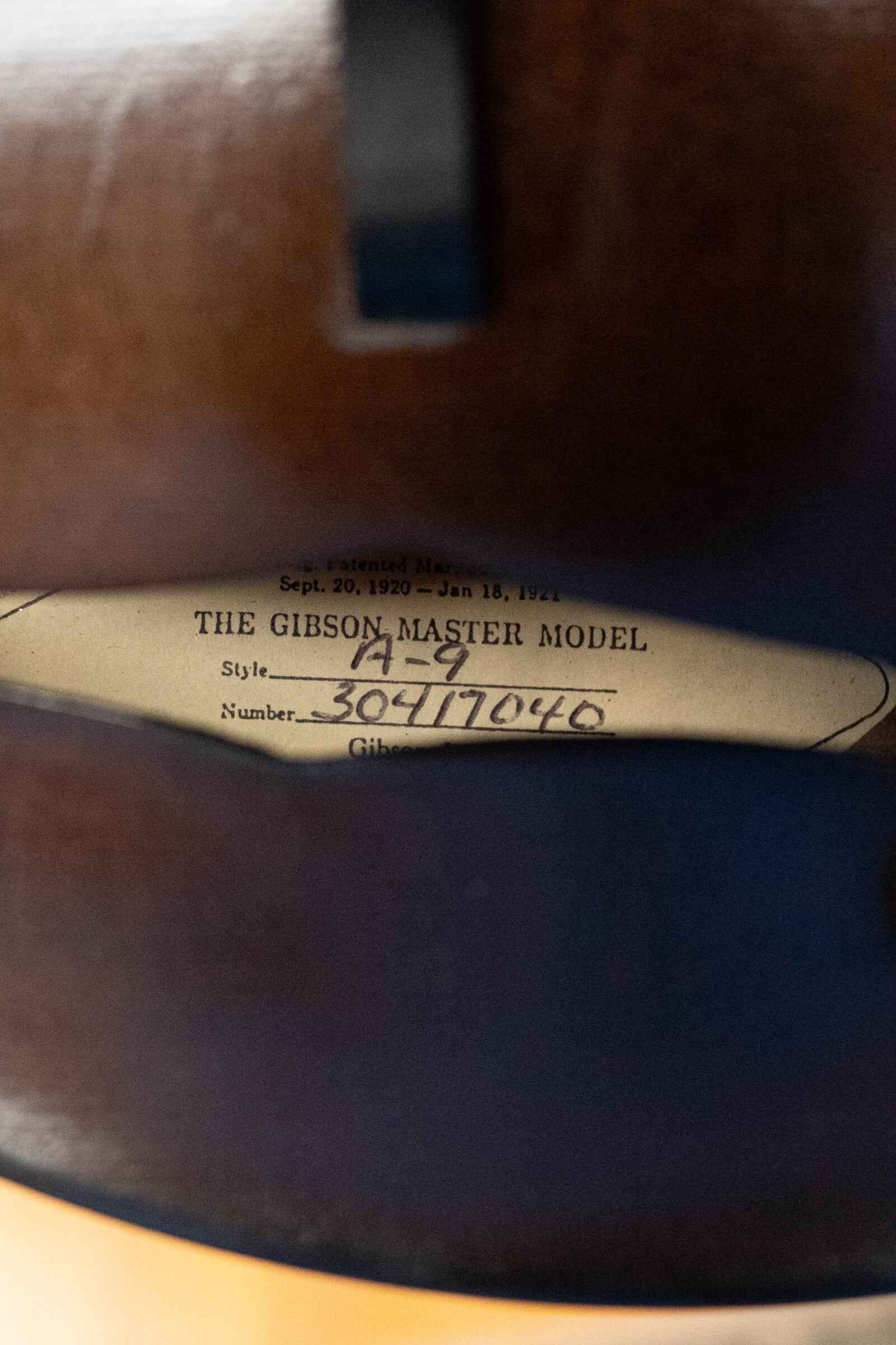 A close-up shows the label inside a (Used) 2003 Gibson Mastermodel A9 Spruce/Maple Mandolin #7040 by Gibson, visible through the f-hole—a classic detail echoing bluegrass tradition.