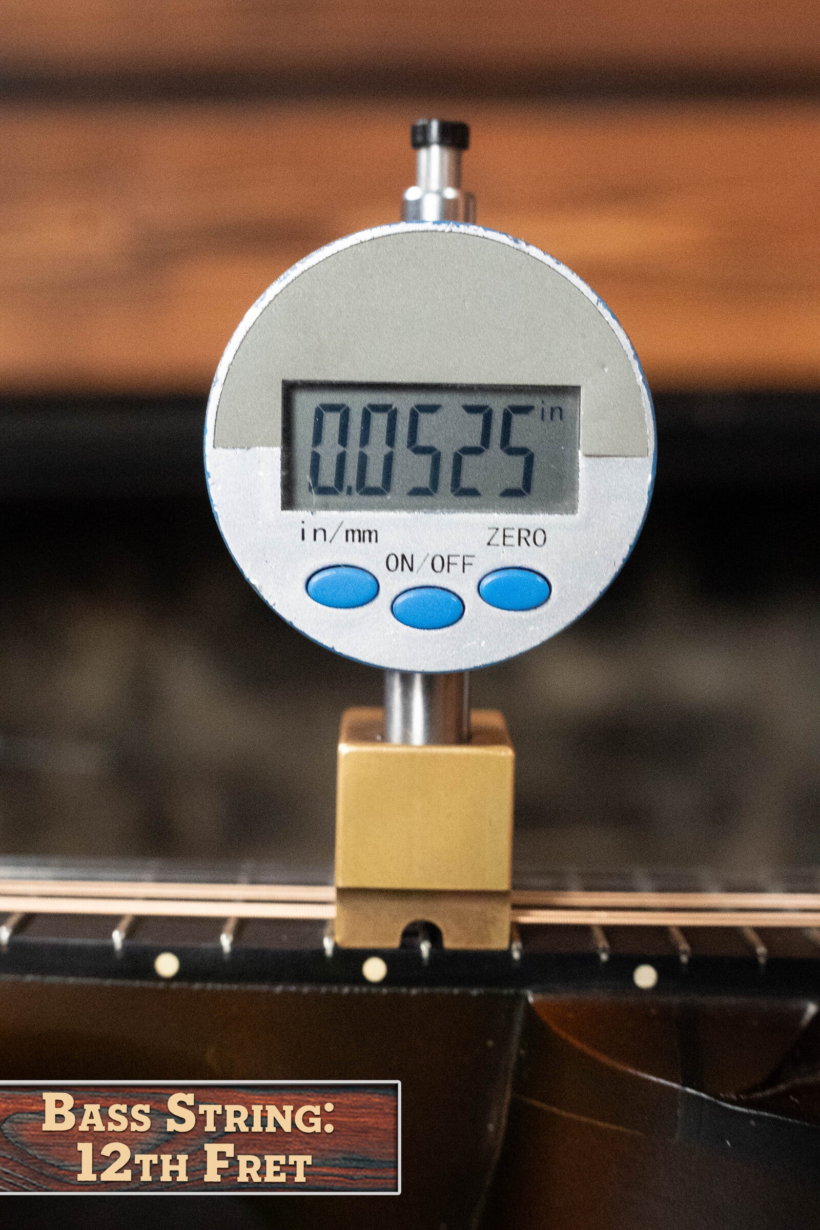 A digital caliper shows 0.0525 inches for the bass string height above the 12th fret on a (Used) 2003 Gibson Mastermodel A9 Spruce/Maple Mandolin #7040 by Gibson. The image is labeled Bass String: 12th Fret.
