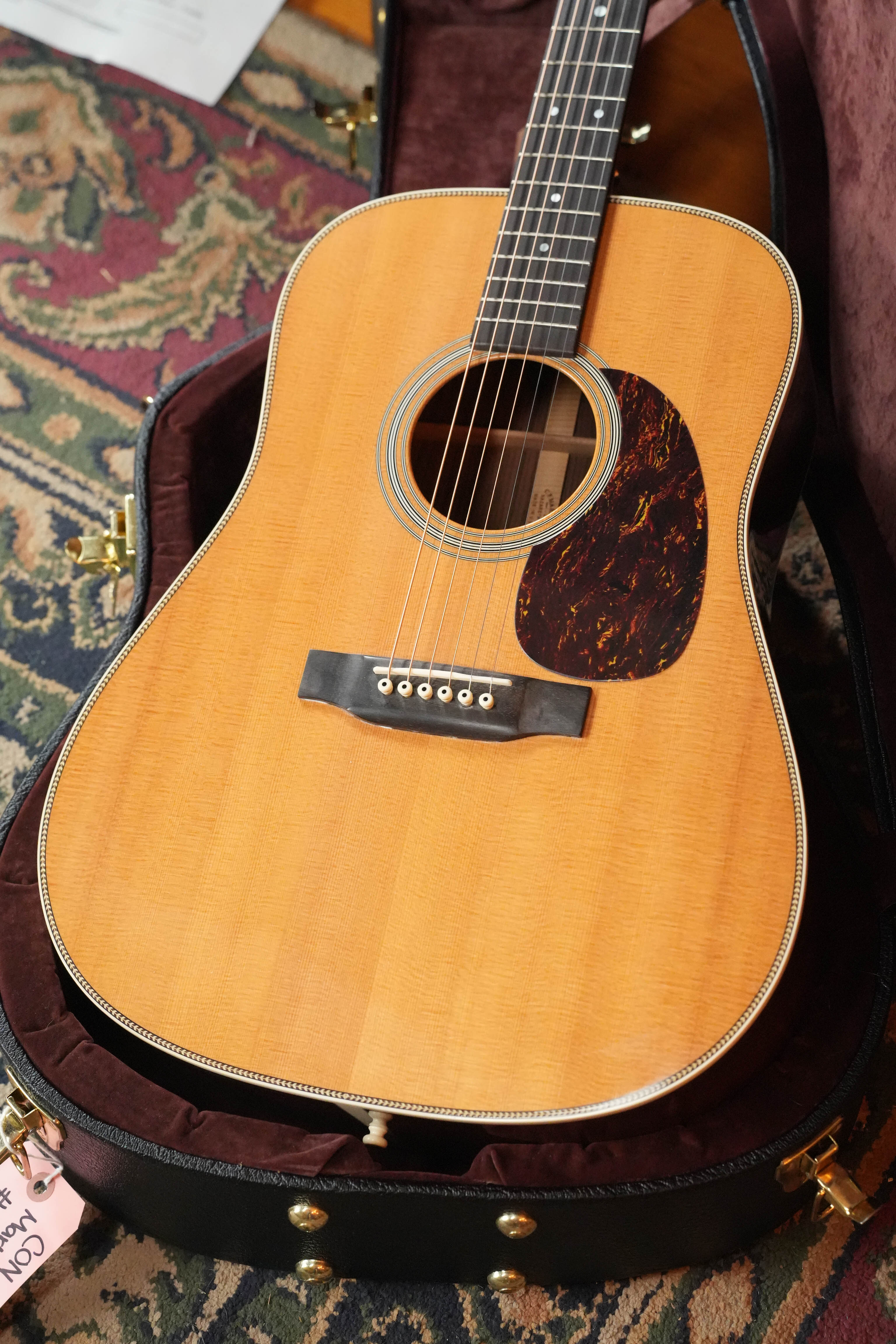 A (Used) 2007 Martin & Co. HD-28 Solid Sitka Spruce/Solid East Indian Rosewood dreadnought acoustic guitar (#9851) with natural finish and dark pickguard rests in an open, velvet-lined case on a patterned rug.