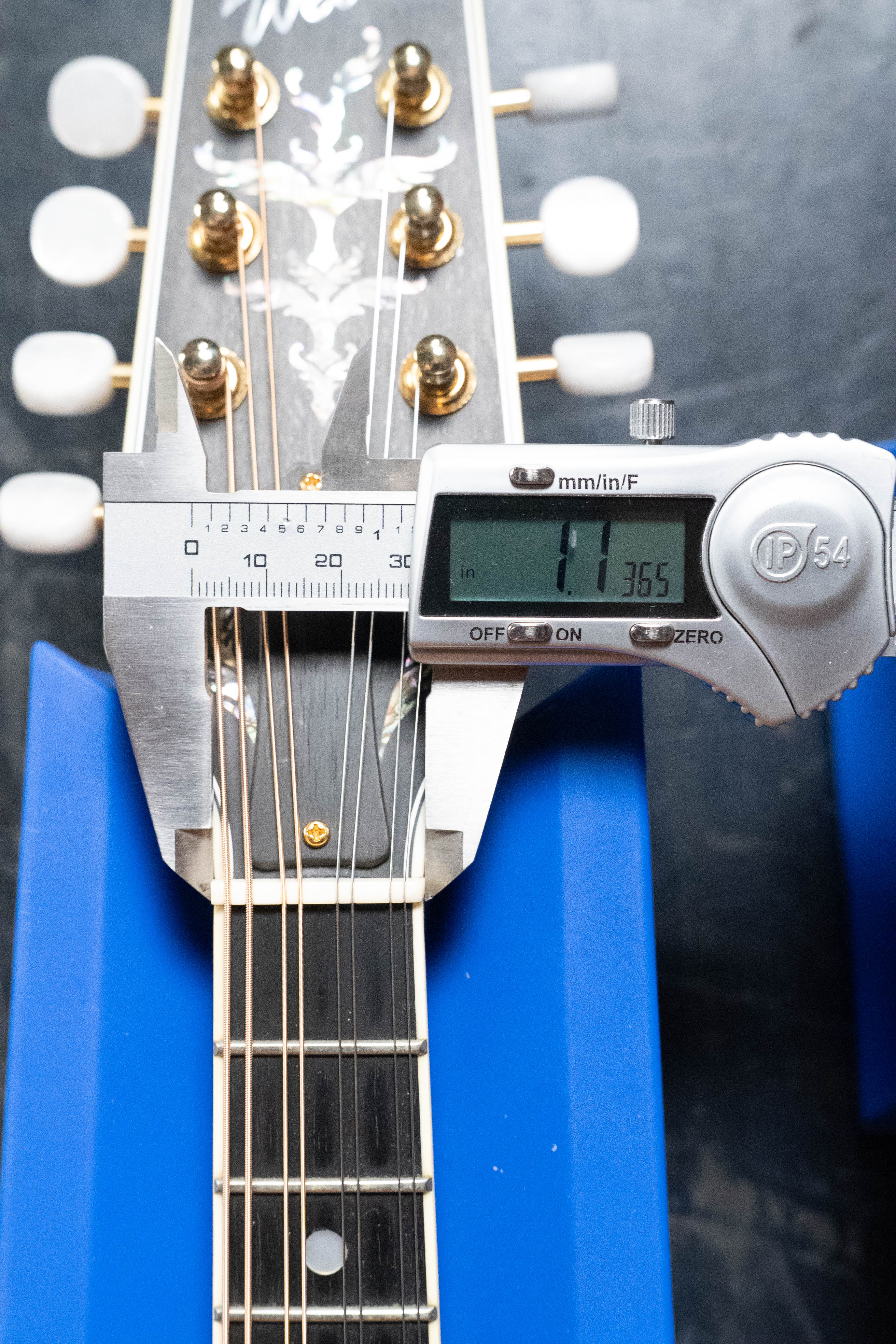 A digital caliper measures the nut width of a (Used) 2016 Weber Fern Red Spruce/Flamed Maple A-Style Mandolin #2801 at 41.365 mm, with tuning pegs and inlay visible as the instrument rests on blue supports.