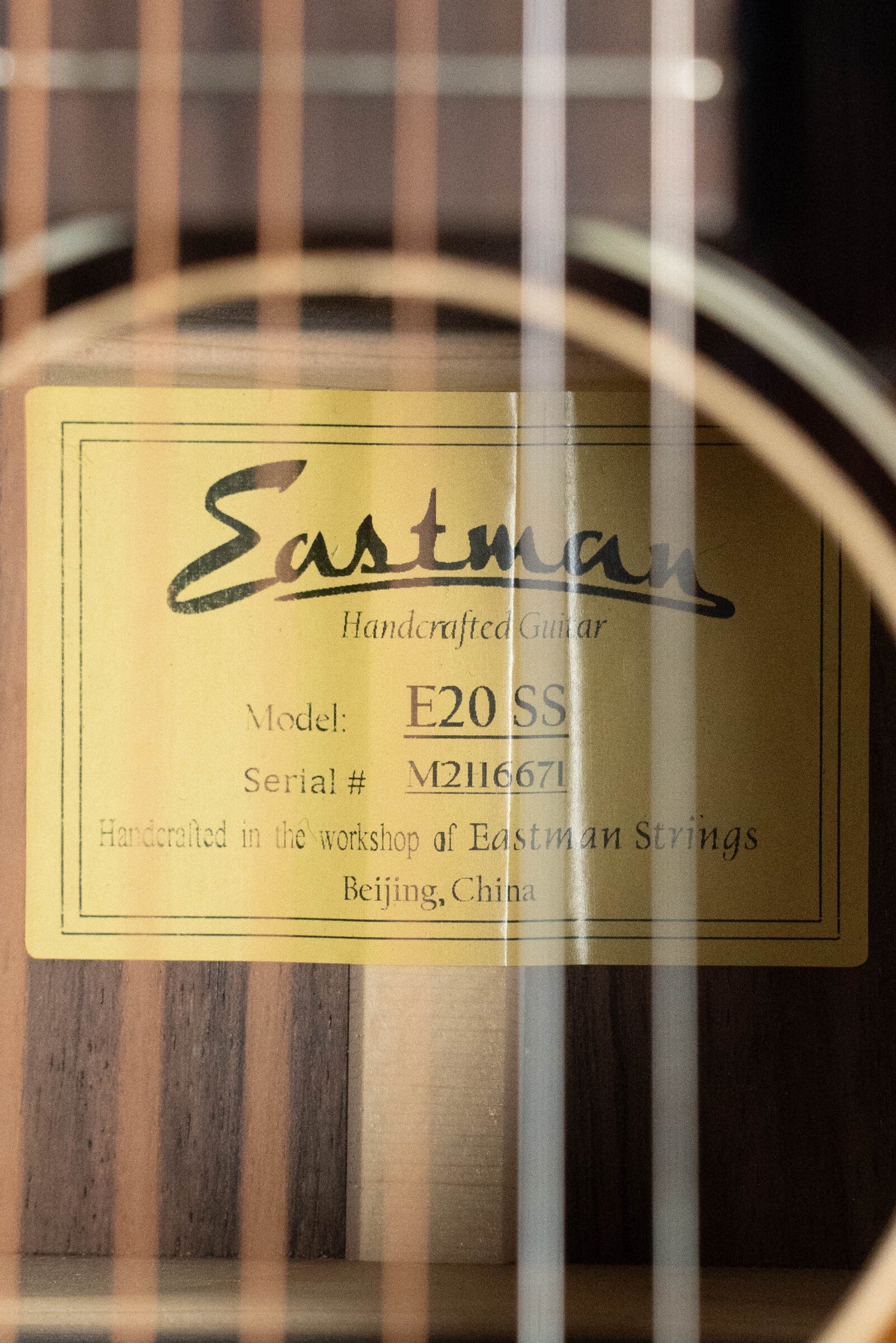 Close-up of the gold label inside a Used 2021 Eastman E20SS Adirondack/Rosewood Slope Shoulder Dreadnought Acoustic Guitar #6671 by Eastman Guitars, showcasing its handcrafted quality.