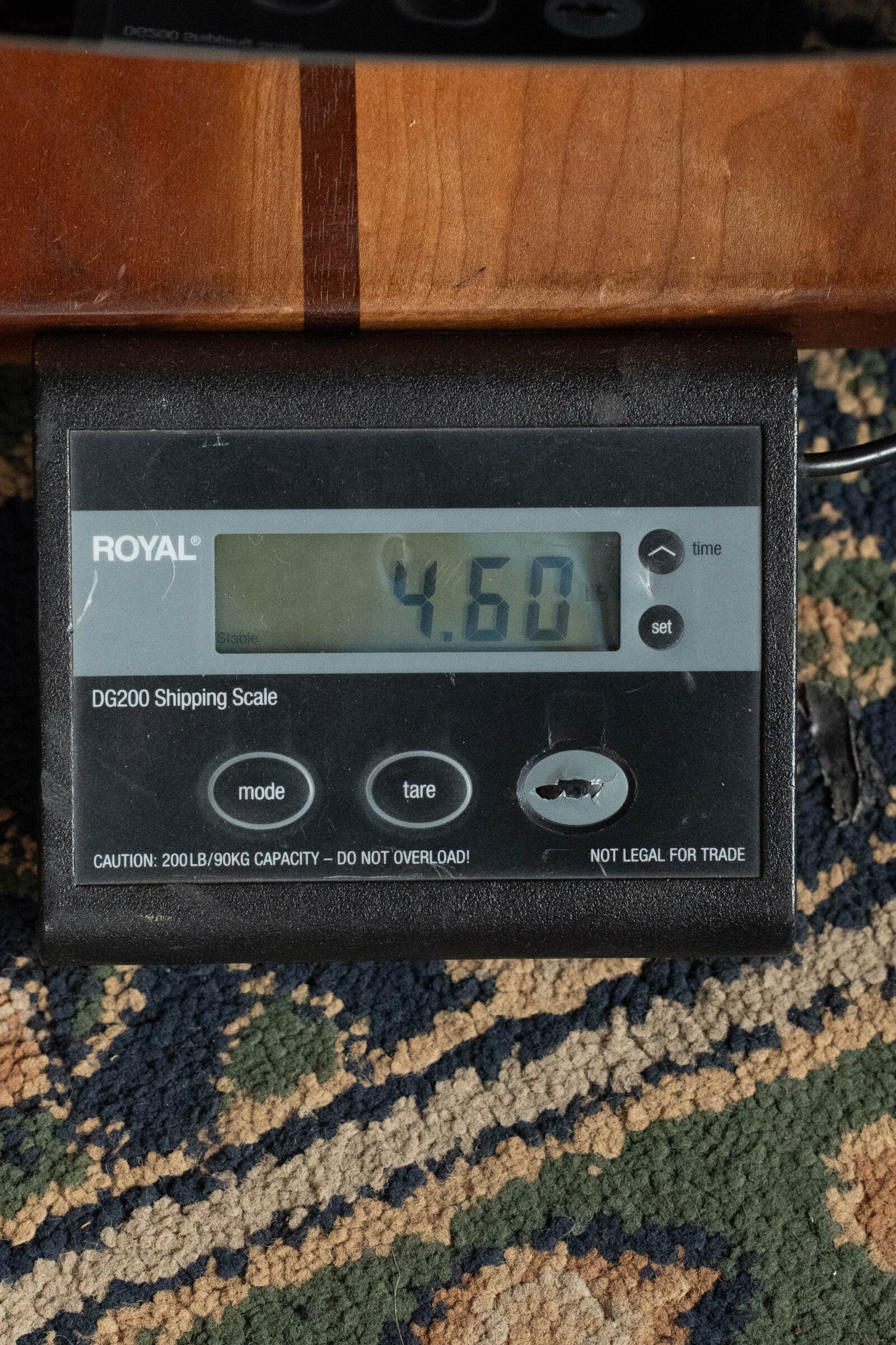A digital shipping scale reads 4.60 lbs on a patterned carpet, with a (Used) 2021 Eastman E20SS Adirondack/Rosewood Slope Shoulder Dreadnought Acoustic Guitar (#6671) by Eastman Guitars resting partially above the scale.