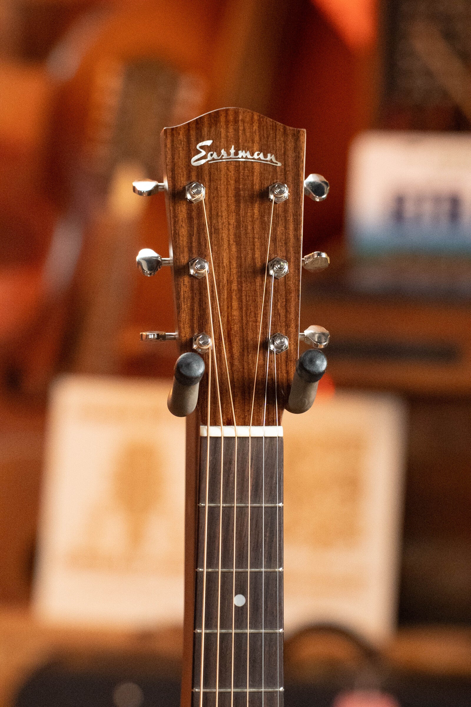 Close-up of the headstock of a (Used) 2021 Eastman E20SS Adirondack/Rosewood Slope Shoulder Dreadnought Acoustic Guitar #6671 by Eastman Guitars, showing tuning pegs and strings, against a softly blurred background.