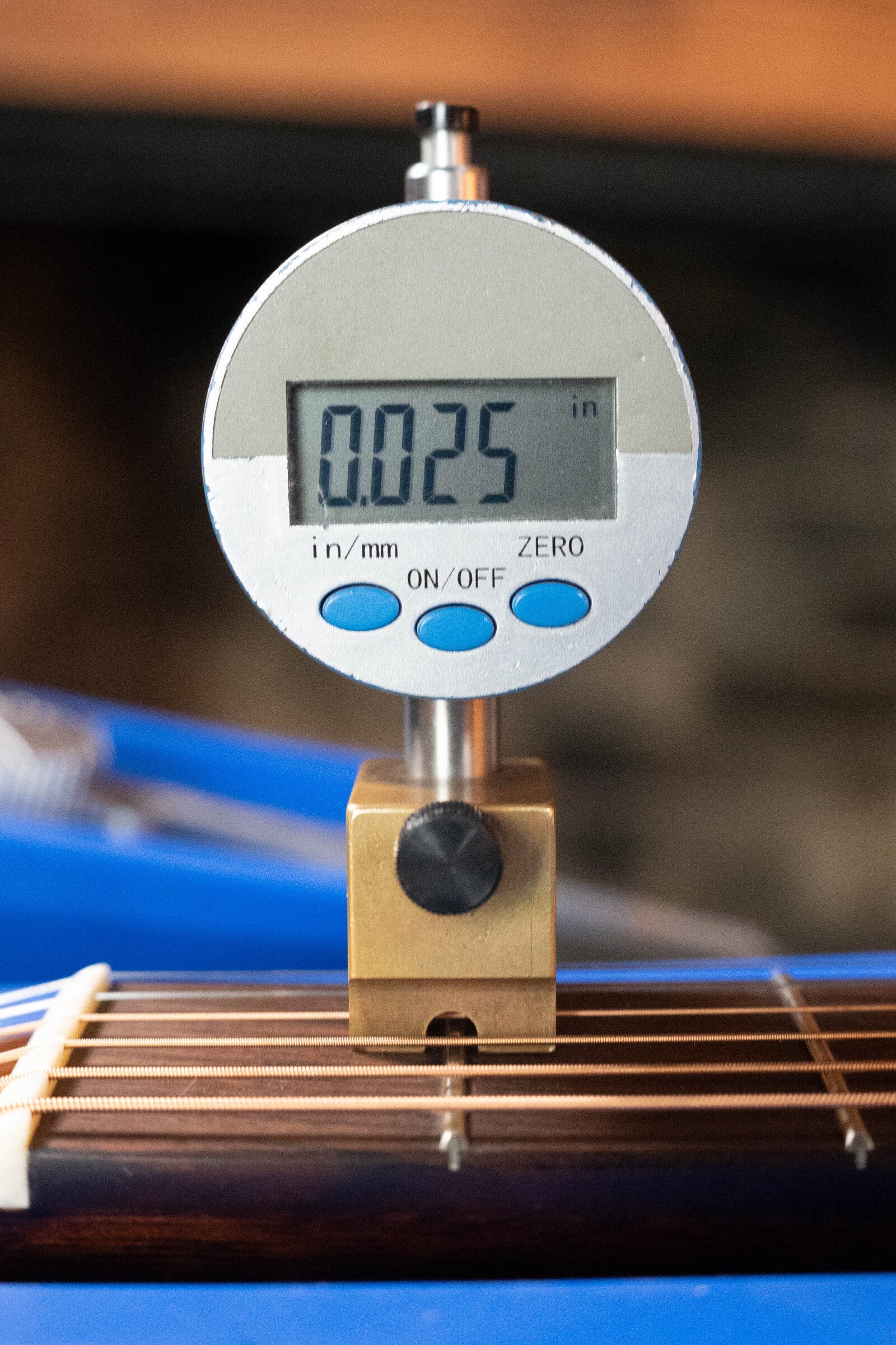 A digital gauge shows a 0.025-inch string action height above the frets on a (Used) 2021 Eastman Guitars E20SS Adirondack/Rosewood Slope Shoulder Dreadnought Acoustic Guitar #6671.