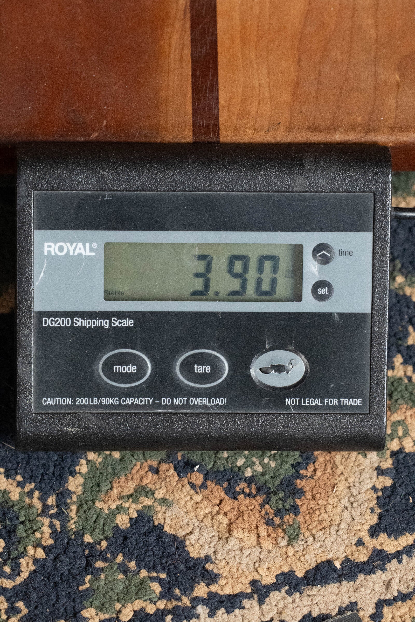 A digital shipping scale shows 3.90 pounds as the ROYAL DG200 rests on a patterned carpet next to a (Used) 2022 Martin Brook Ligertwood 000-28 Spruce/Rosewood OOO Acoustic Guitar by Martin & Co., and a wooden surface.