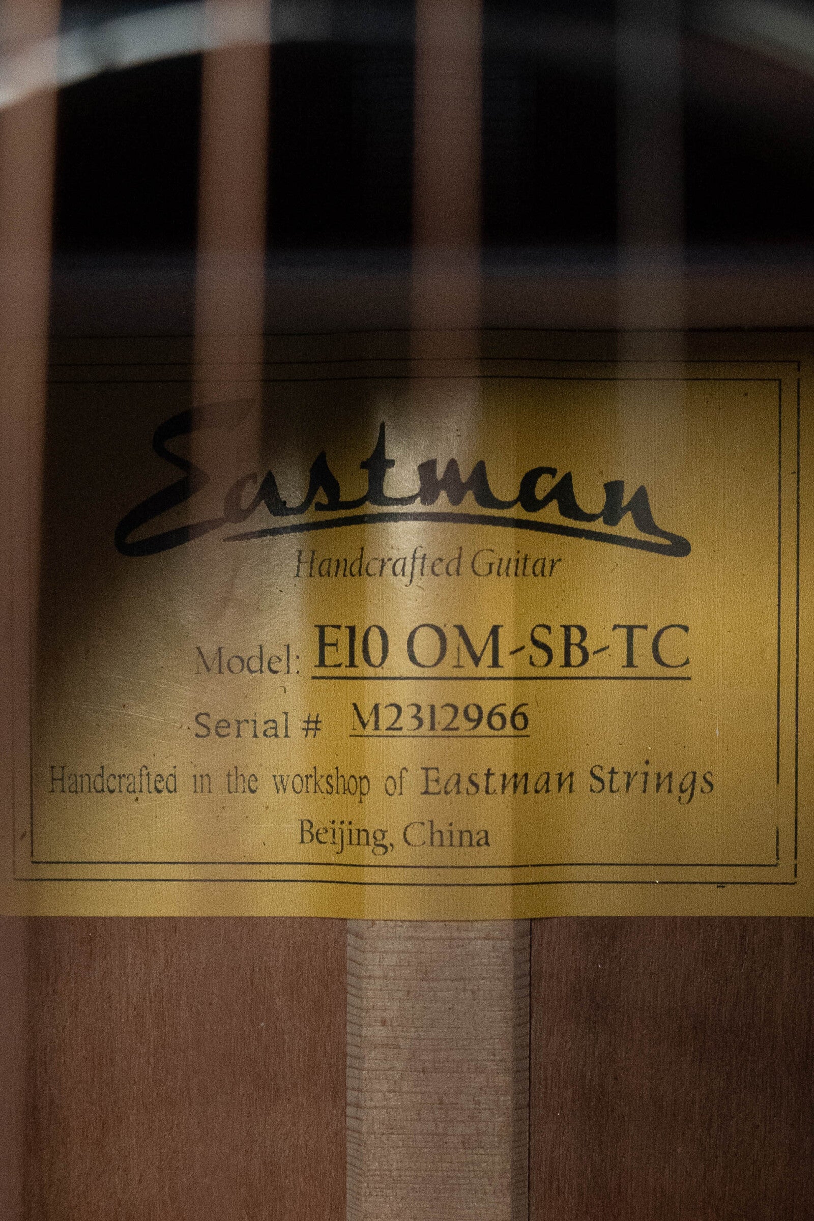 Close-up of the label inside a (Used) 2023 Eastman Guitars E10OM-TC-SB Orchestra Model acoustic guitar #2966, featuring Thermo-Cured Adirondack spruce and mahogany, handcrafted in Beijing, China.