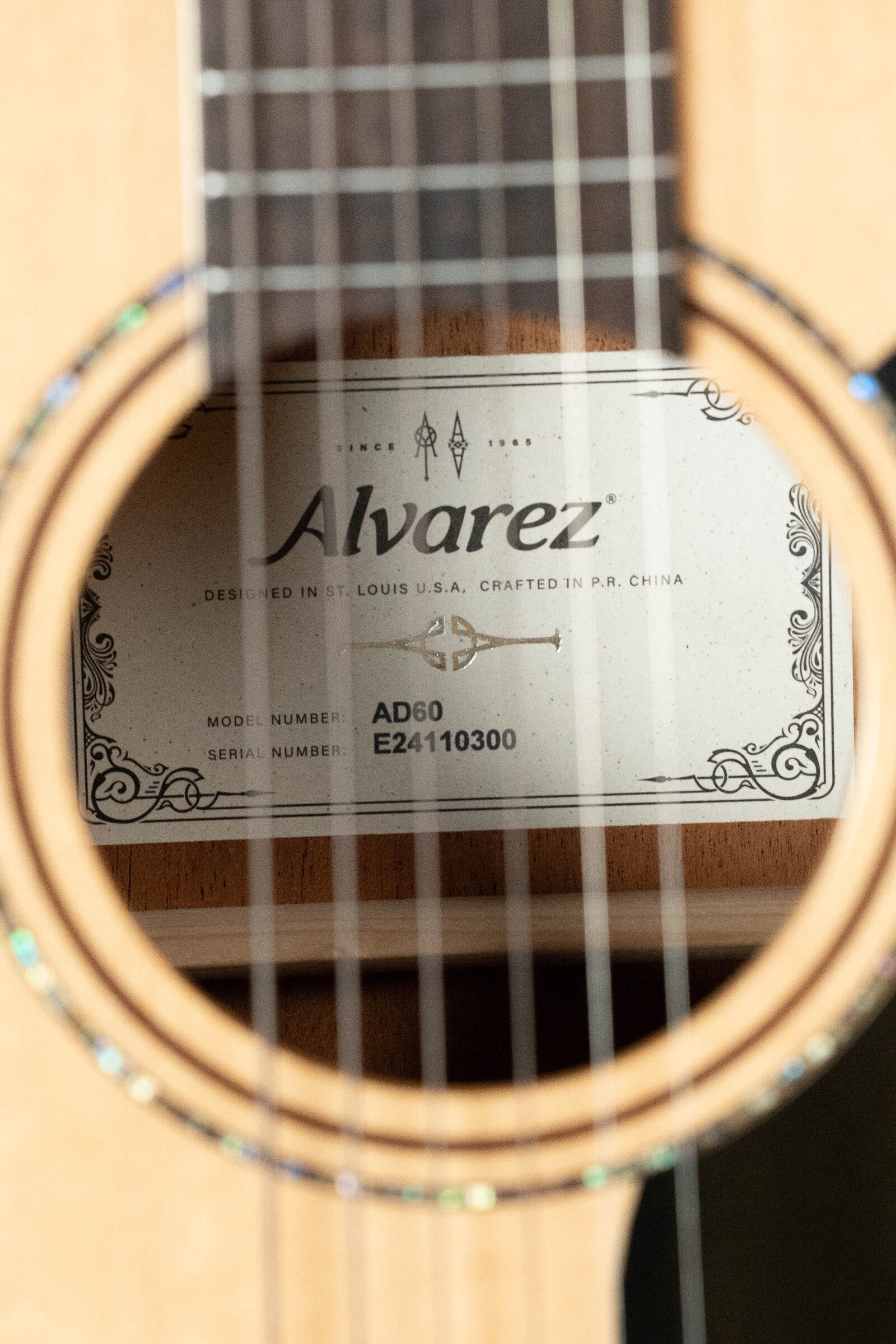 Close-up of a used 2024 Alvarez AD60 Sitka/Mahogany Dreadnought Acoustic Guitar #0300 soundhole, showing the Alvarez label and model number inside.