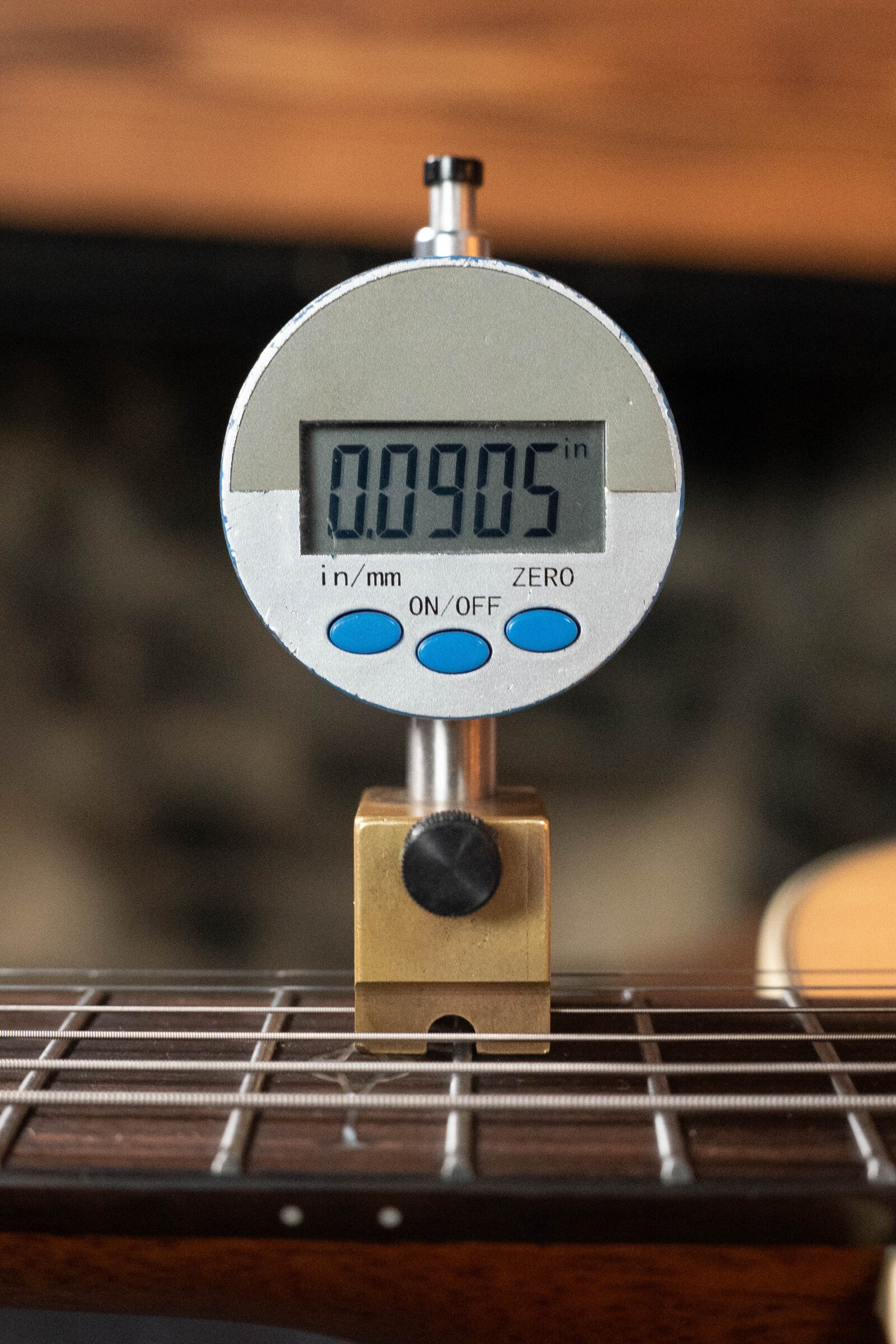 A digital caliper reads 0.0905 inches when measuring the gap above the strings on a (Used) 2024 Alvarez AD60 Sitka/Mahogany Dreadnought Acoustic Guitar #0300 from Alvarez.