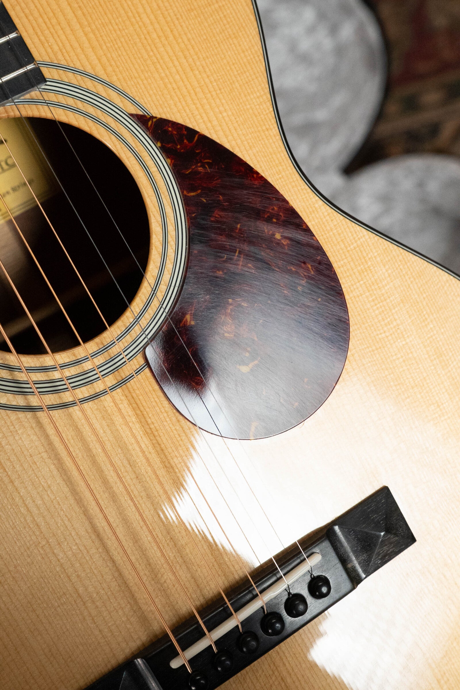 Close-up of a (Used) 2024 Eastman Guitars E10OO-TC Acoustic (#0268), showing the sound hole, strings, pickguard, and bridge on a light Thermo-Cured Adirondack Spruce top with mahogany back and sides.