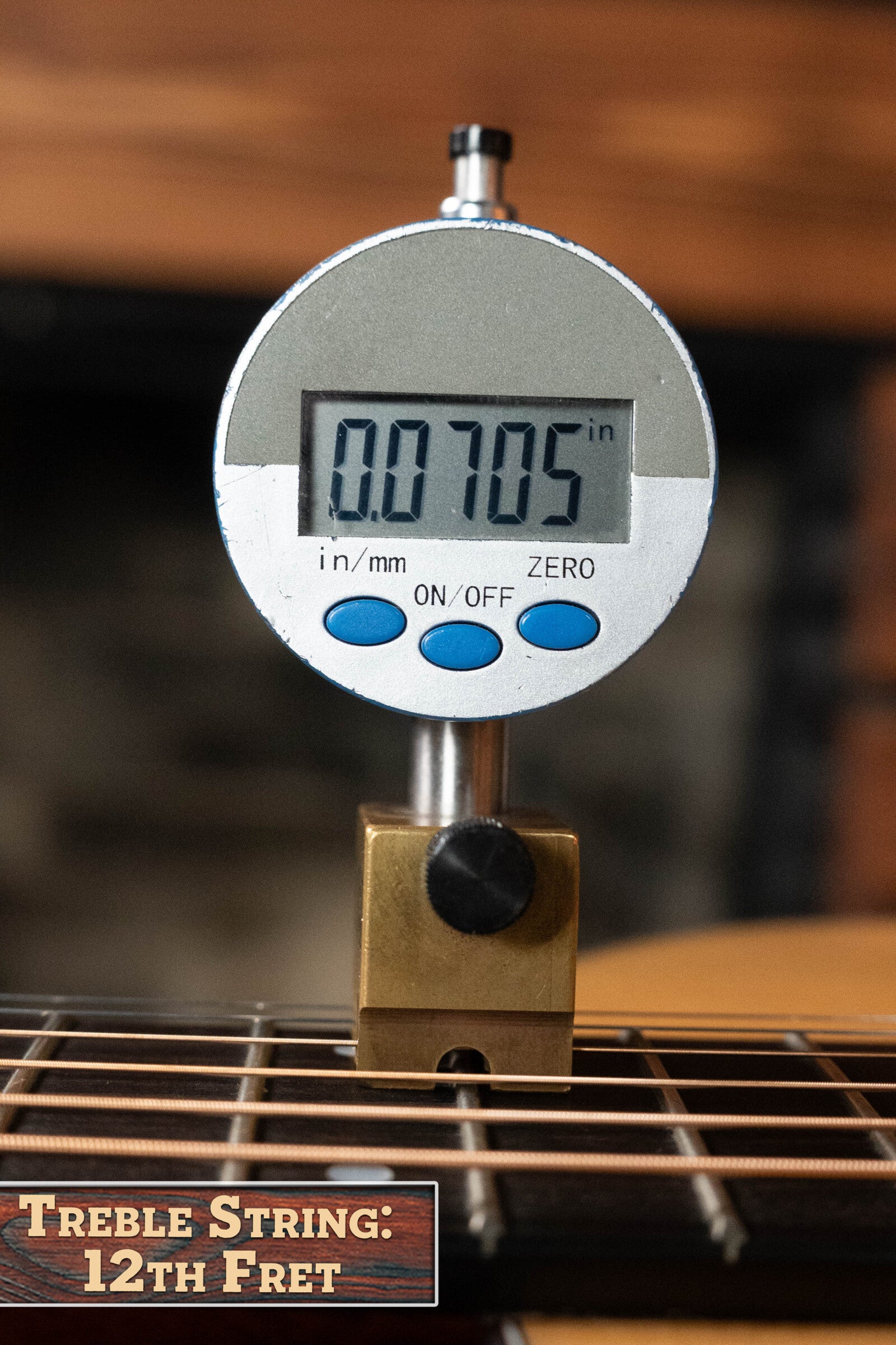 A digital gauge shows the treble string height above the 12th fret on a (Used) 2024 Eastman Guitars E10OO-TC Thermo-Cure Adirondack/Mahogany Acoustic Guitar #0268 as 0.0705", with a label at bottom left: Treble String: 12th Fret.