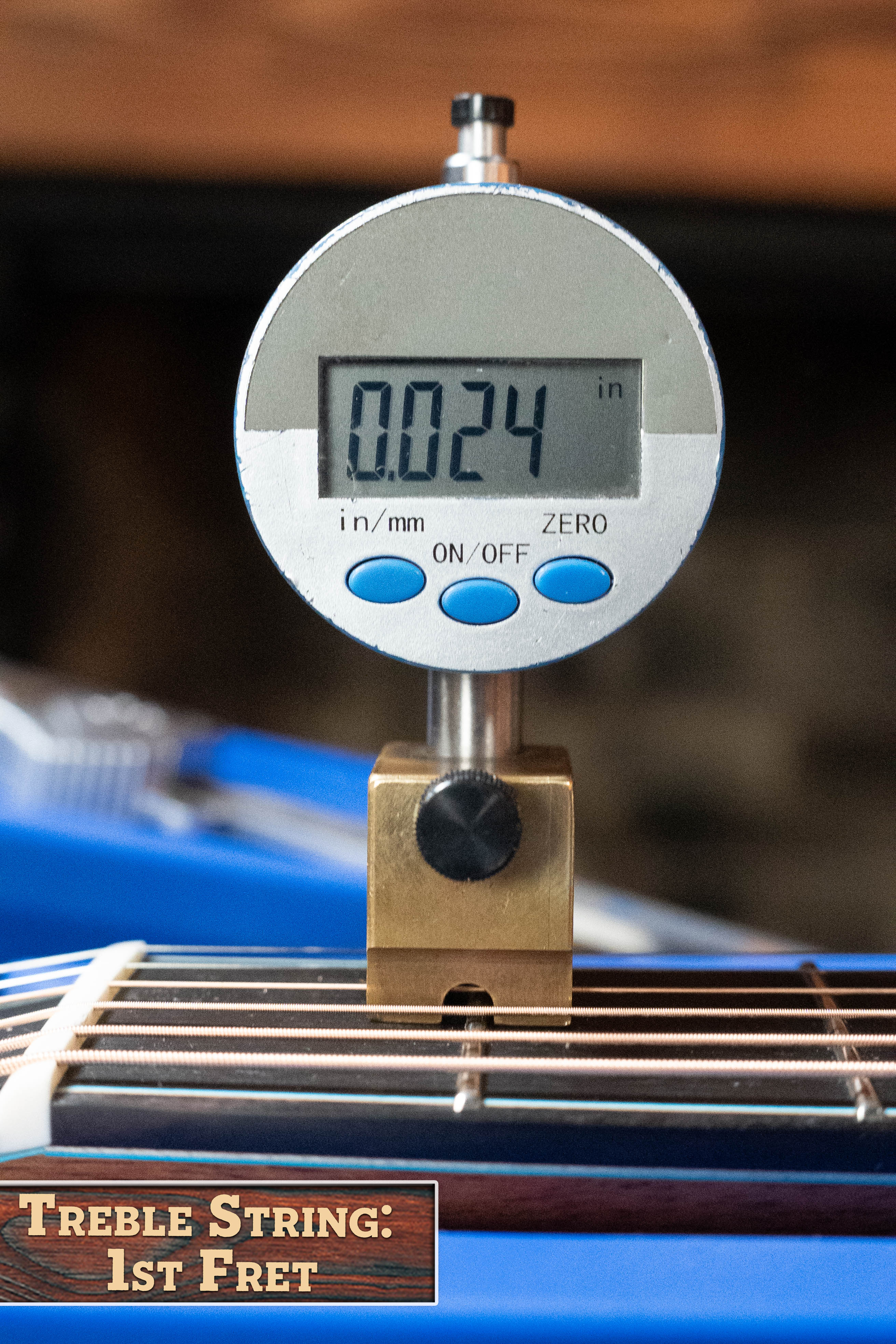 A digital gauge shows 0.024 inches for the treble string at the 1st fret of this (Used) 2025 Eastman L-OOSS-LTD-KOA Limited Edition Luthier Series All Koa Acoustic Guitar (#9075) by Eastman Guitars. Label reads: Treble String: 1st Fret.