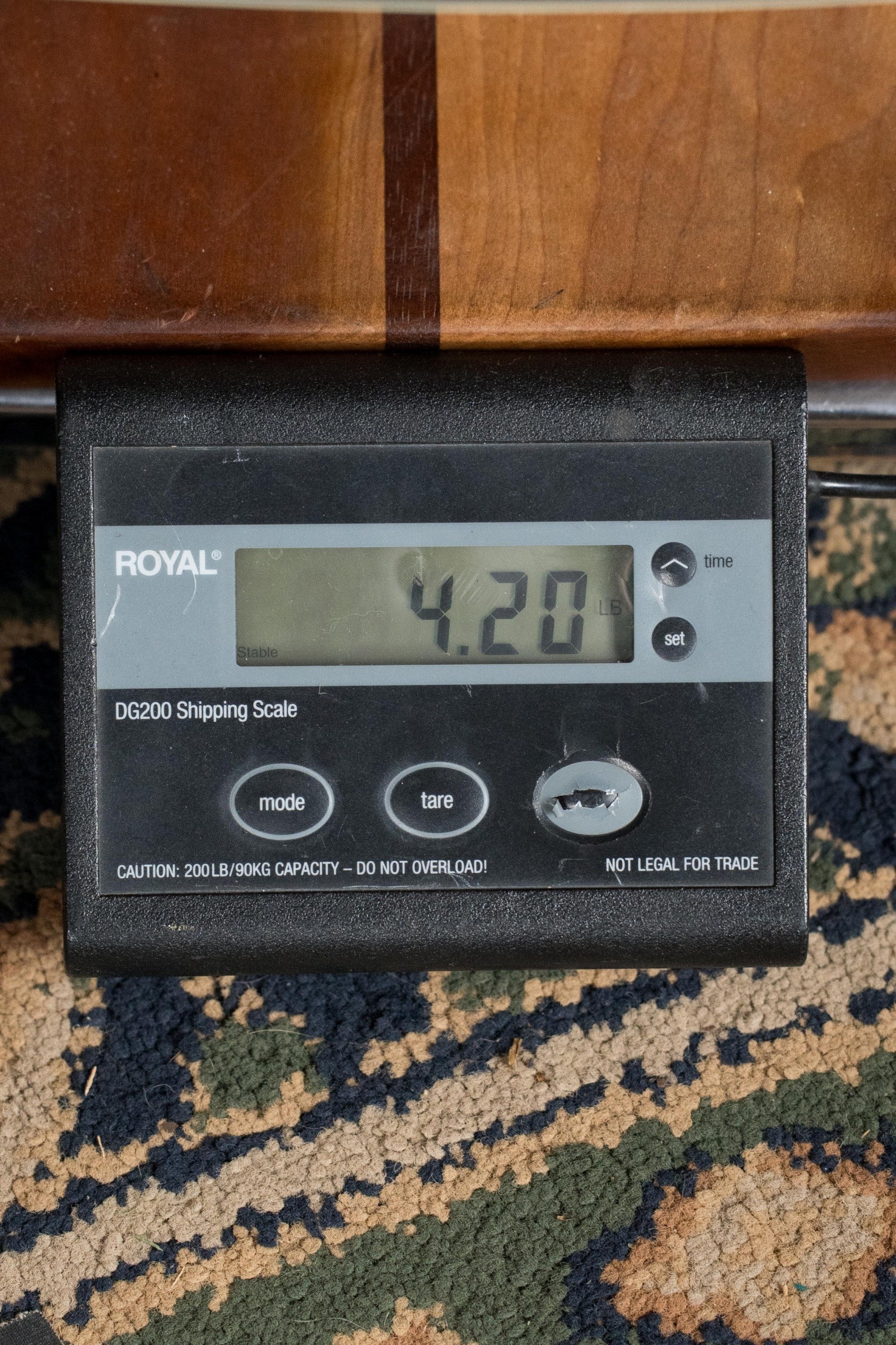 A digital shipping scale reads 4.20 lbs as a (Used) Gibson J45 Standard Sitka/Mahogany Round Shoulder Vintage Sunburst Dreadnought Guitar w/K&K Pickup (#4111) by Gibson rests on a patterned carpet, with wood visible at the top of the image.