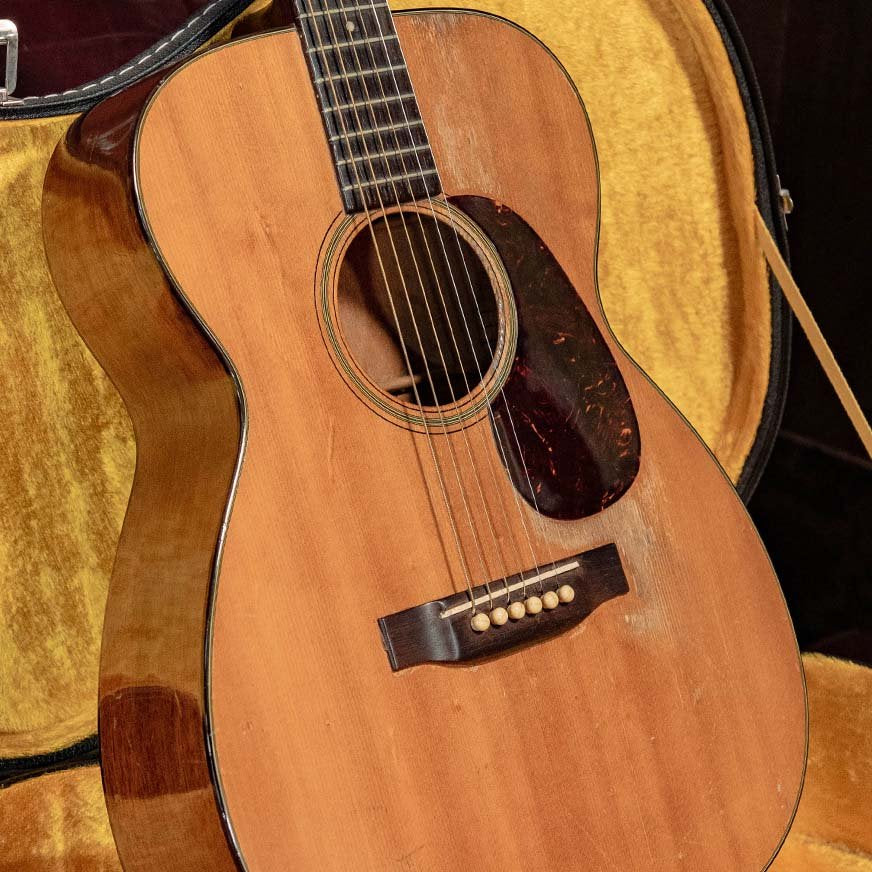 A vintage Tone-Gard Mandolin by Tone-Gard rests in an open, plush-lined case, showing visible scratches and marks on its body. Its natural wood finish and included Tone-Gard back protector highlight signs of use and authenticity.