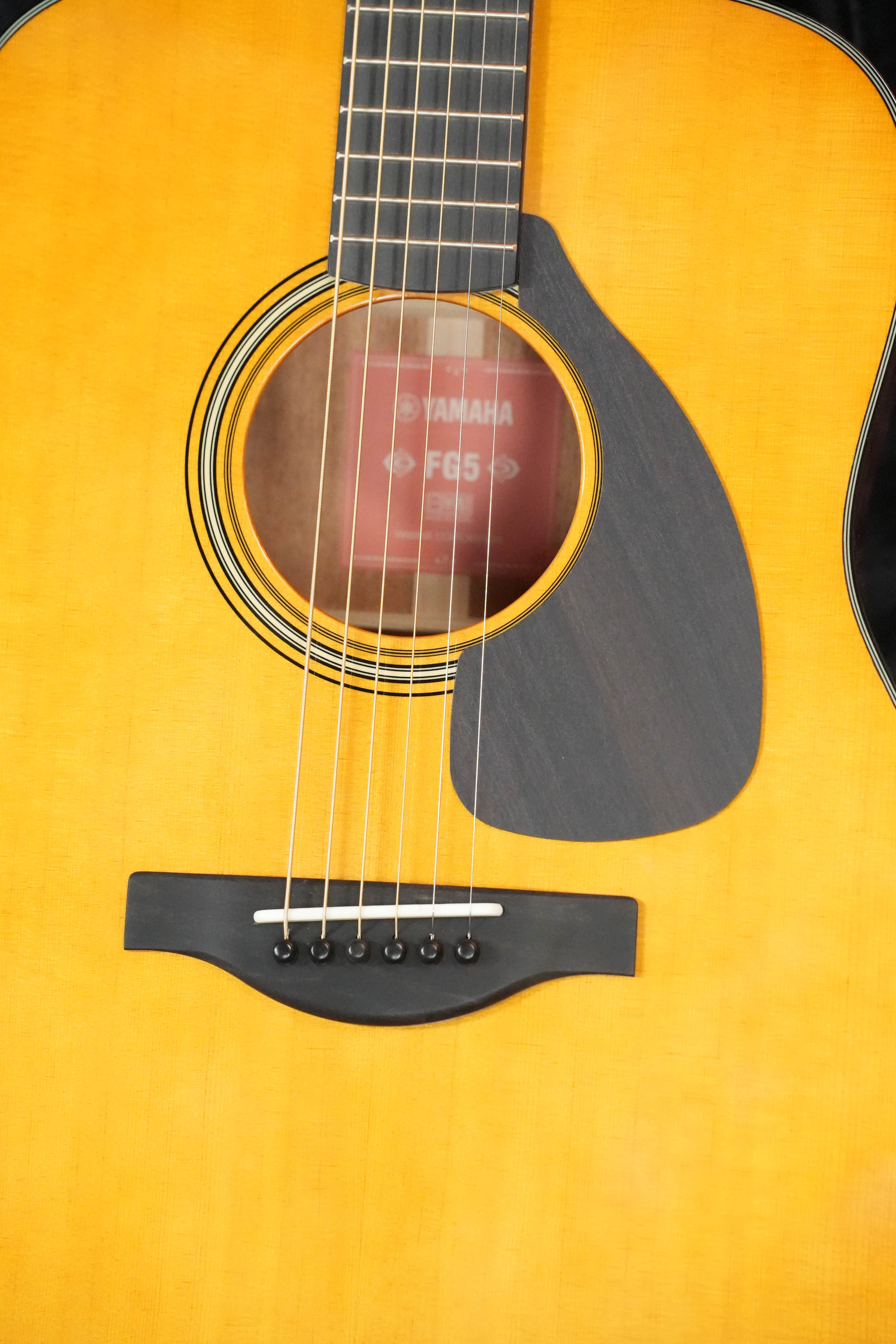 Close-up of Yamaha FG5 GL NEW Gloss Red Label Dreadnought Acoustic Guitar #227A, showing body, strings, sound hole with label, black pickguard, and solid Sitka spruce top with Acoustic Resonance Enhancement.