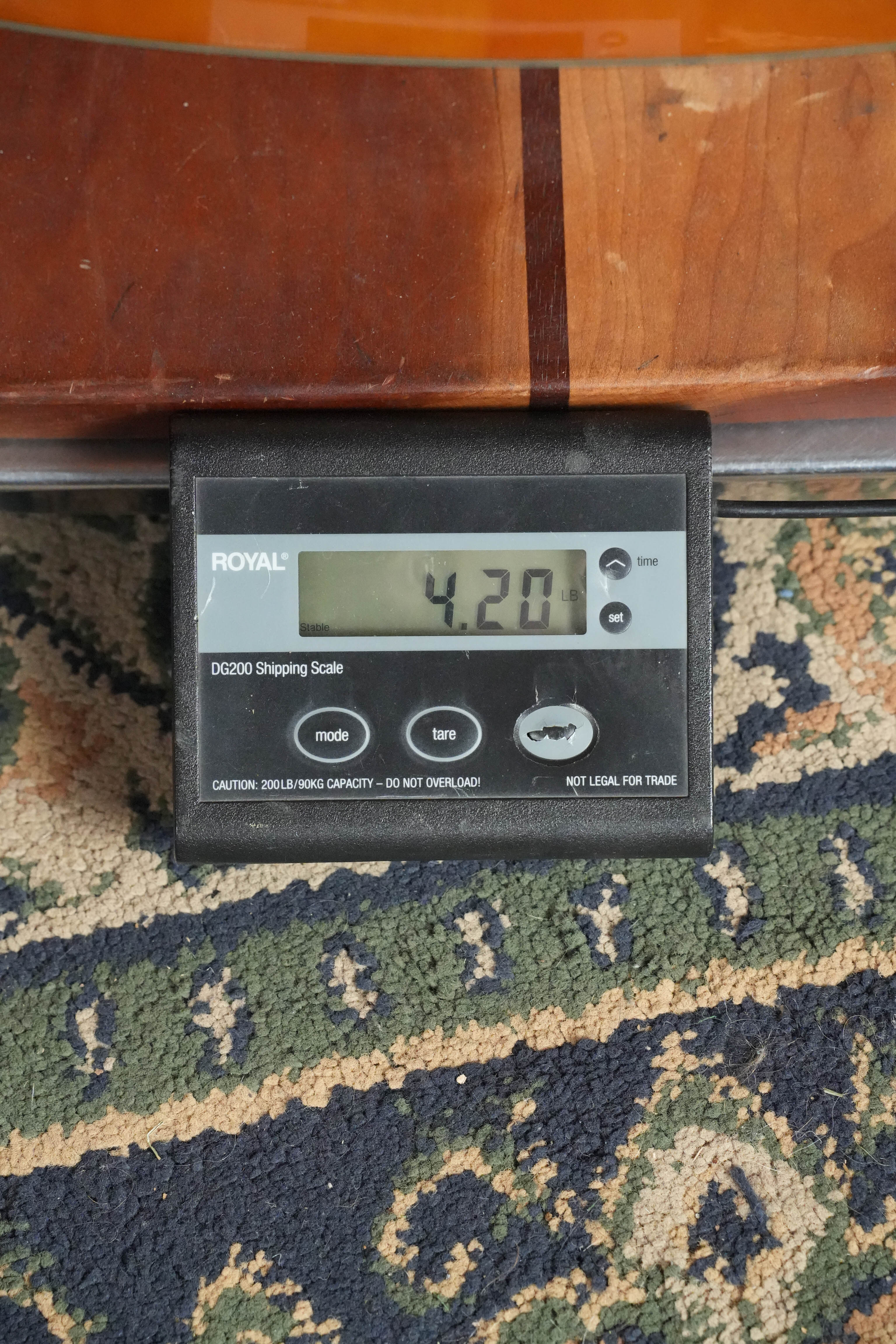 A Yamaha FG5 GL NEW Gloss Red Label Dreadnought Acoustic Guitar (#732A) rests partly on a digital shipping scale atop a patterned rug, showing a weight of 4.20 pounds.