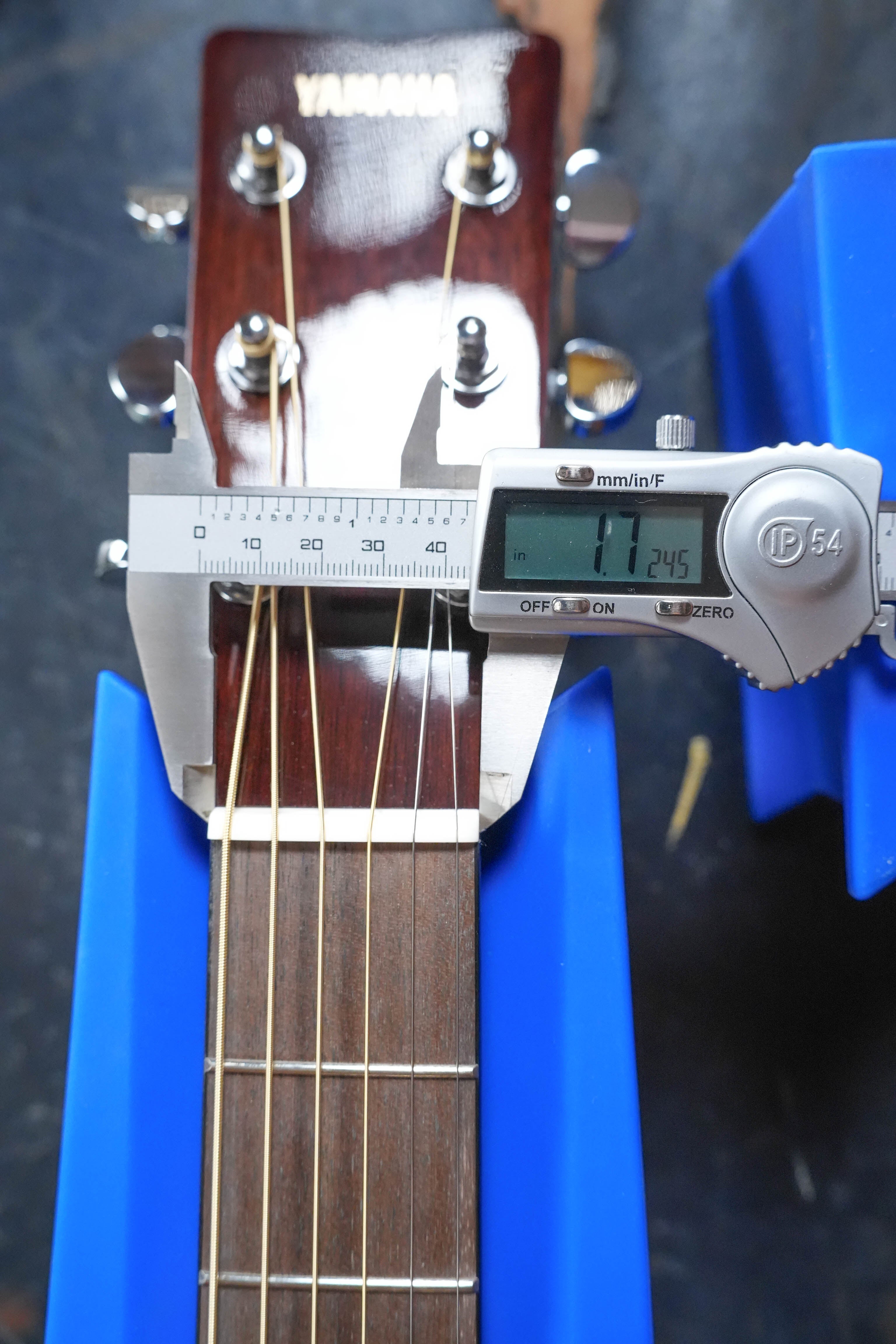 A Yamaha TAG1E TBL Transacoustic Dreadnought Guitar #1280, featuring spruce and mahogany, has a nut width of 1.245 inches measured by digital caliper; it includes built-in reverb and chorus effects.