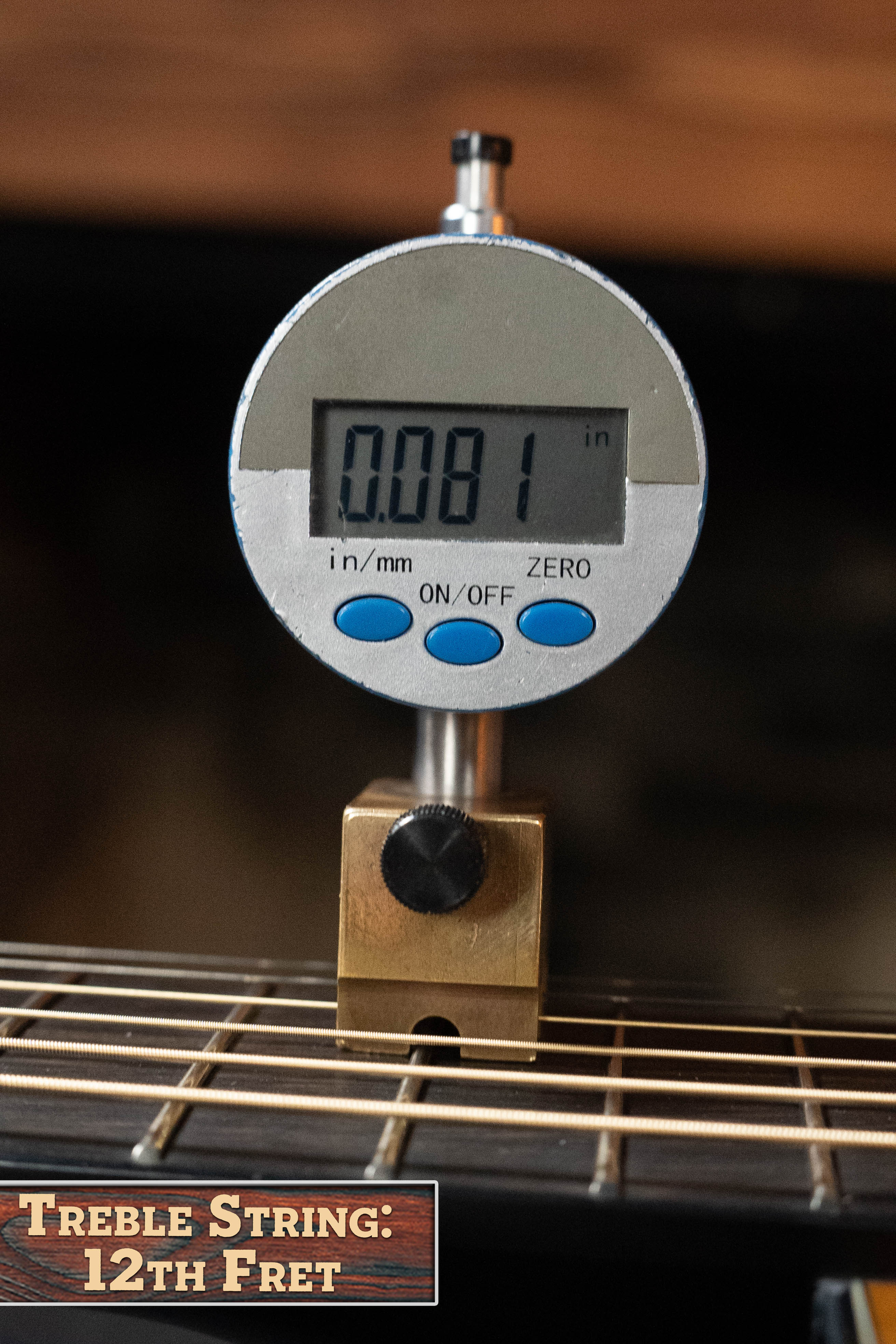 A digital gauge measures a 0.081-inch distance above the 12th fret treble string on the Yamaha TAG3C-SDB Sitka/Mahogany Sandburst Dreadnought Guitar with the NEWEST TransAcoustic System #0688.