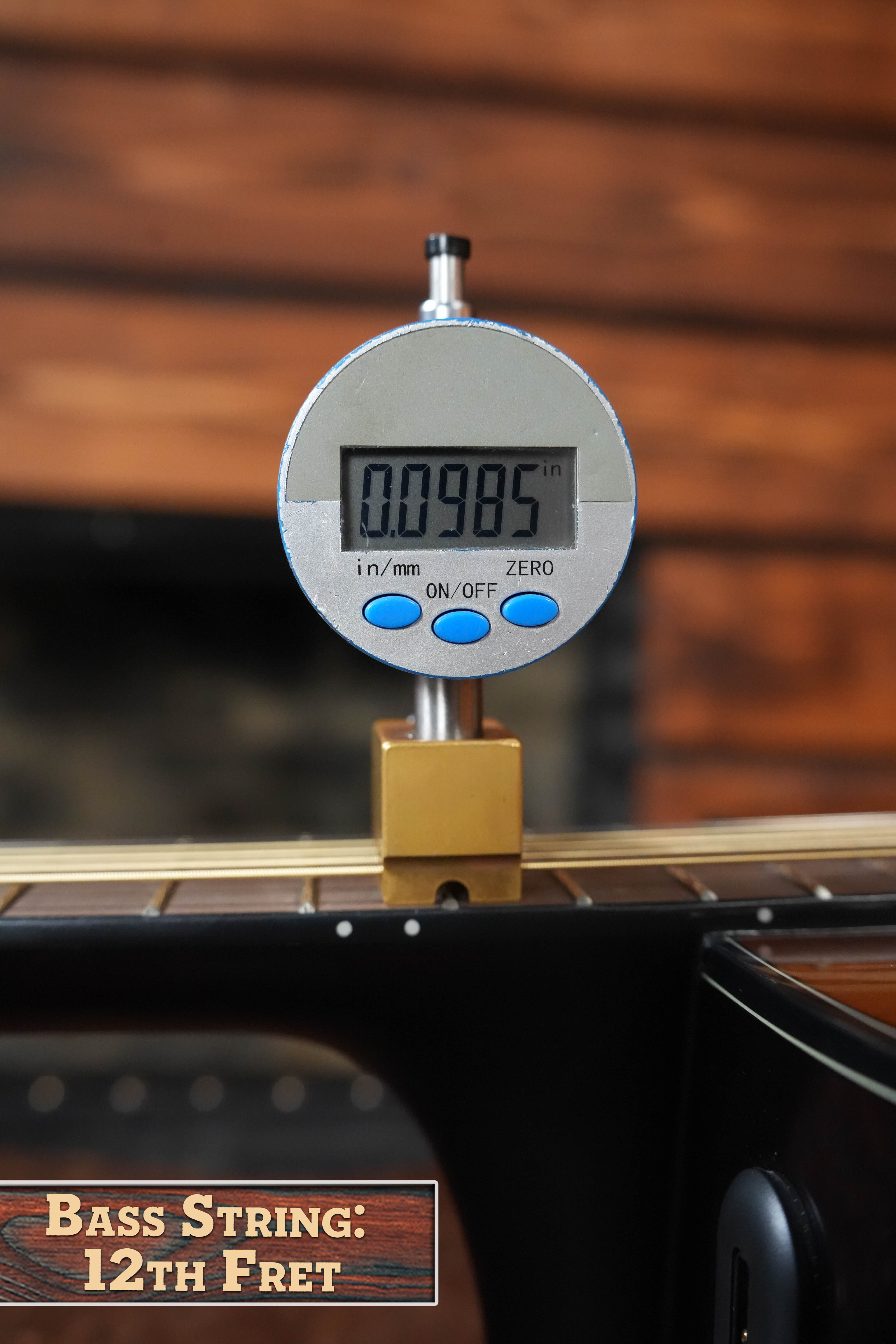 A digital gauge shows a Yamaha TAS1 C Sitka/Mahogany Concert Guitar string at the 12th fret measures 0.0985 inches, set against wood grain and a Bass String: 12th Fret label reflecting its Sitka spruce craftsmanship.