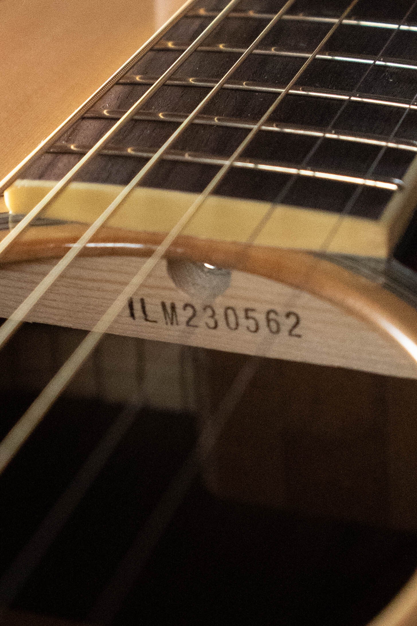 Close-up of a Yamaha FG830 Spruce/Laminate Rosewood Natural Dreadnought Acoustic Guitar #0562, showing the fretboard, strings, and serial number "ILM230562" printed inside the soundhole.