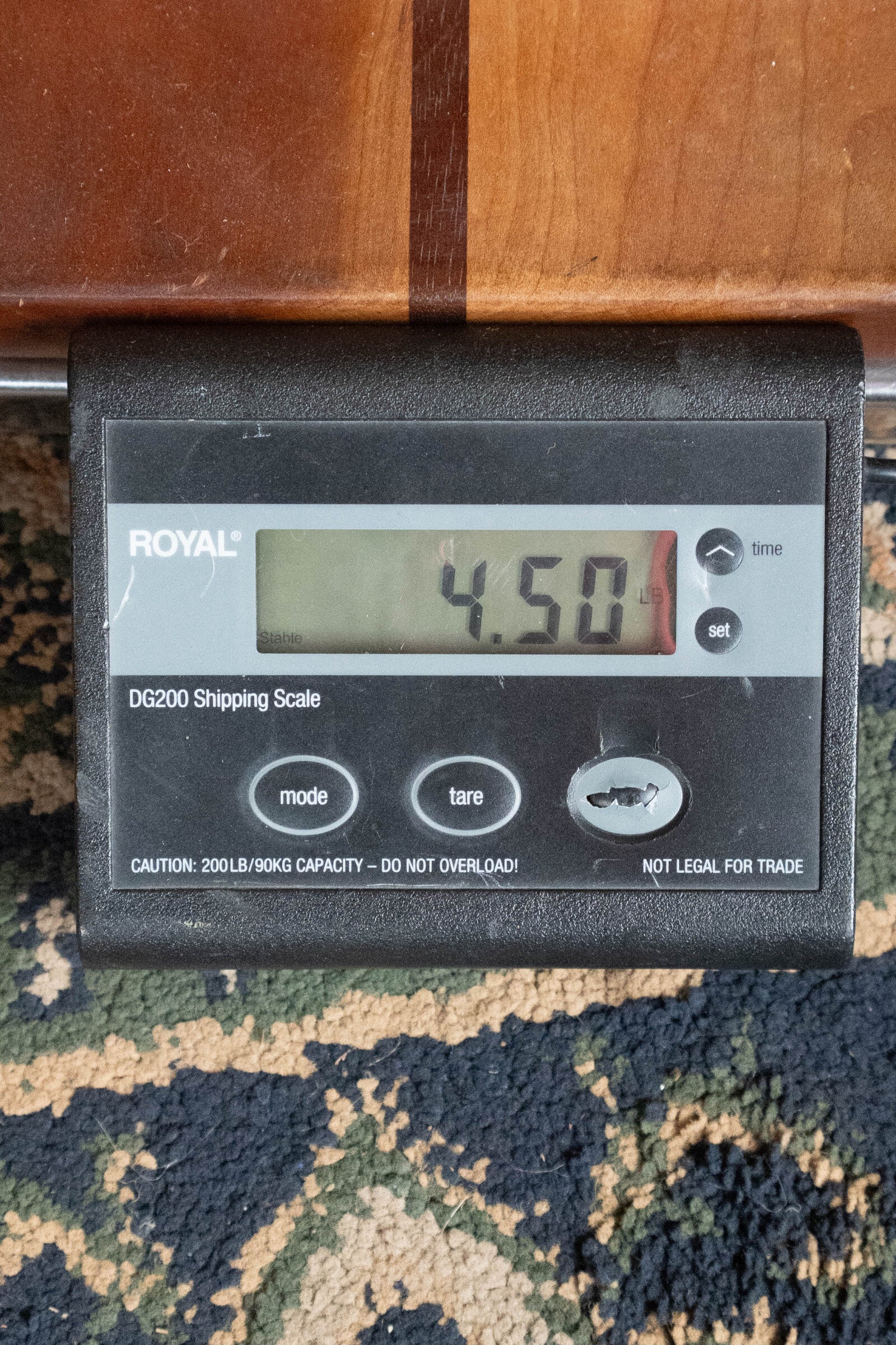 A digital shipping scale labeled "Royal" displays 4.50 pounds on a patterned carpet, with part of a Yamaha FG830 Spruce/Laminate Rosewood Natural Dreadnought Acoustic Guitar #0562 visible above it.