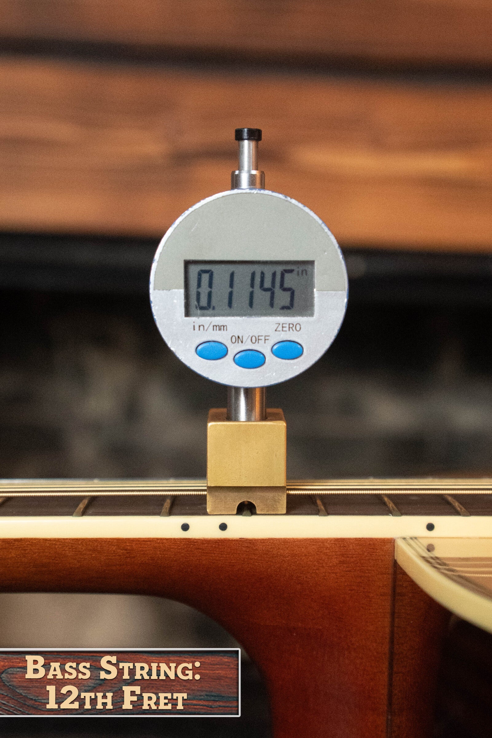 A digital gauge shows 0.1145 inches at the 12th fret of a Yamaha FG830 Spruce/Laminate Rosewood Natural Dreadnought Acoustic Guitar #0562. The label reads "Bass String: 12th Fret," set against a blurred wood and stone background.