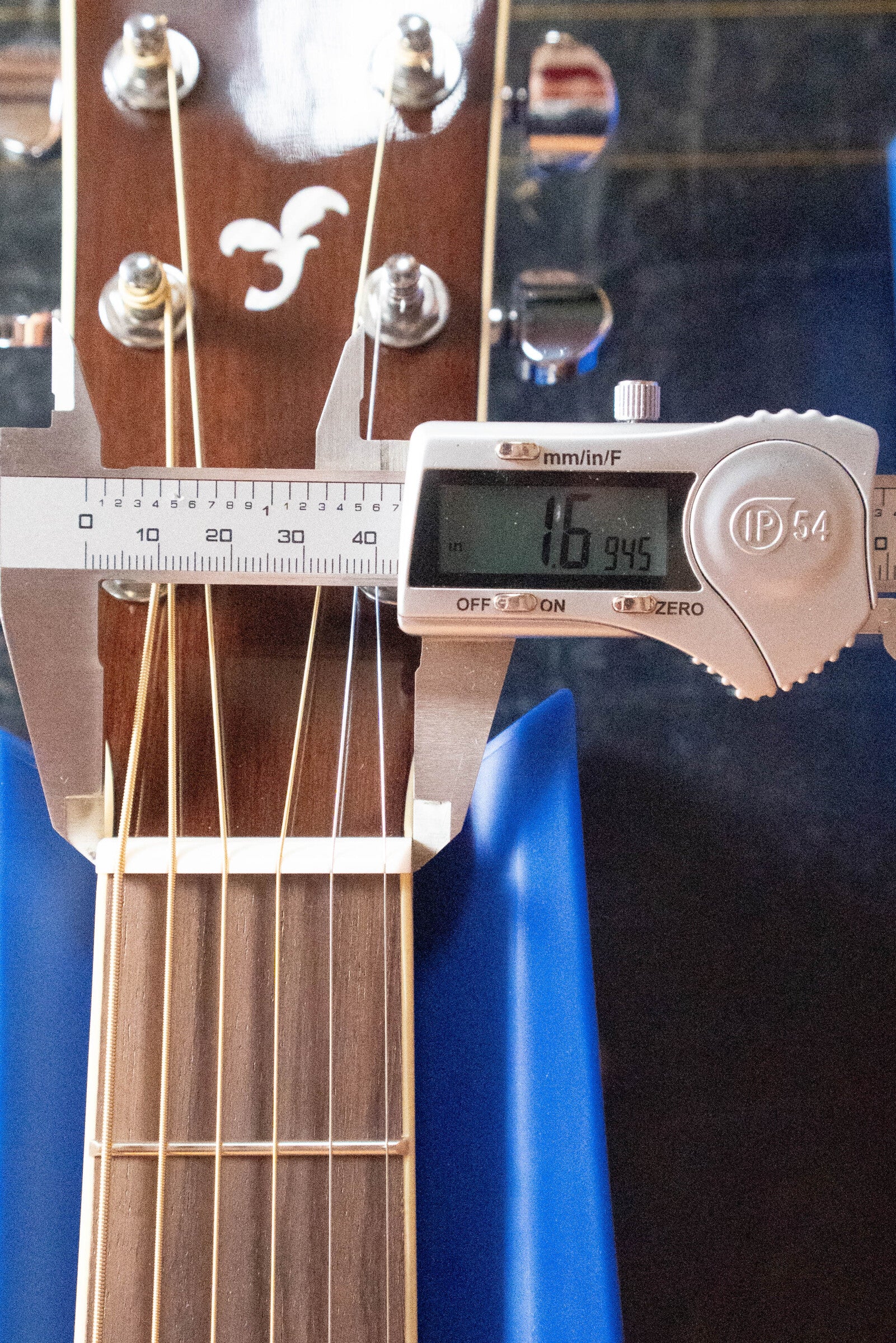 A digital caliper shows the Yamaha FG830 Spruce/Laminate Rosewood Natural Dreadnought Acoustic Guitar #0600 nut width as 16.945 mm, with the brown headstock, white logo, and guitar strings clearly visible in the display.