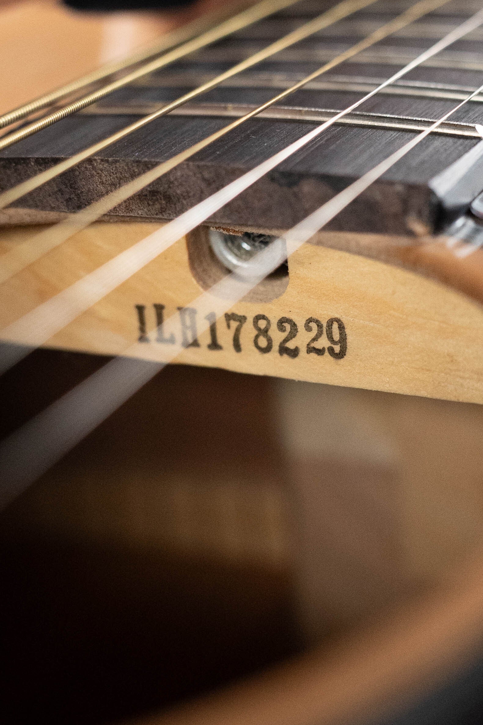Close-up of the Yamaha GigMaker Deluxe Acoustic Pack - Natural Finish #8229 neck joint, showing metal strings, wood details, and #8229 stamped on the body.
