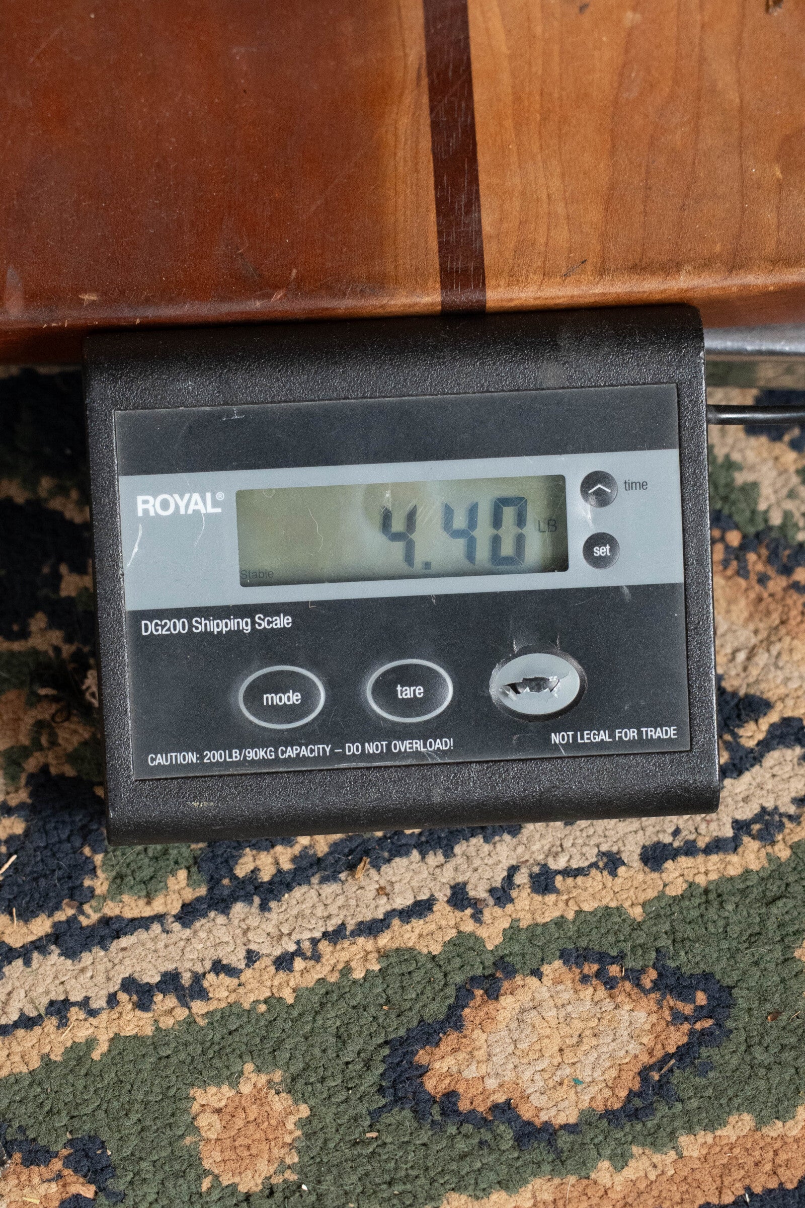 A digital black ROYAL scale with mode and tare buttons shows the Yamaha GigMaker Deluxe Acoustic Pack - Natural Finish #8229 by Yamaha weighing 4.40 lbs on a patterned carpet—ideal for weighing your starter guitar pack.