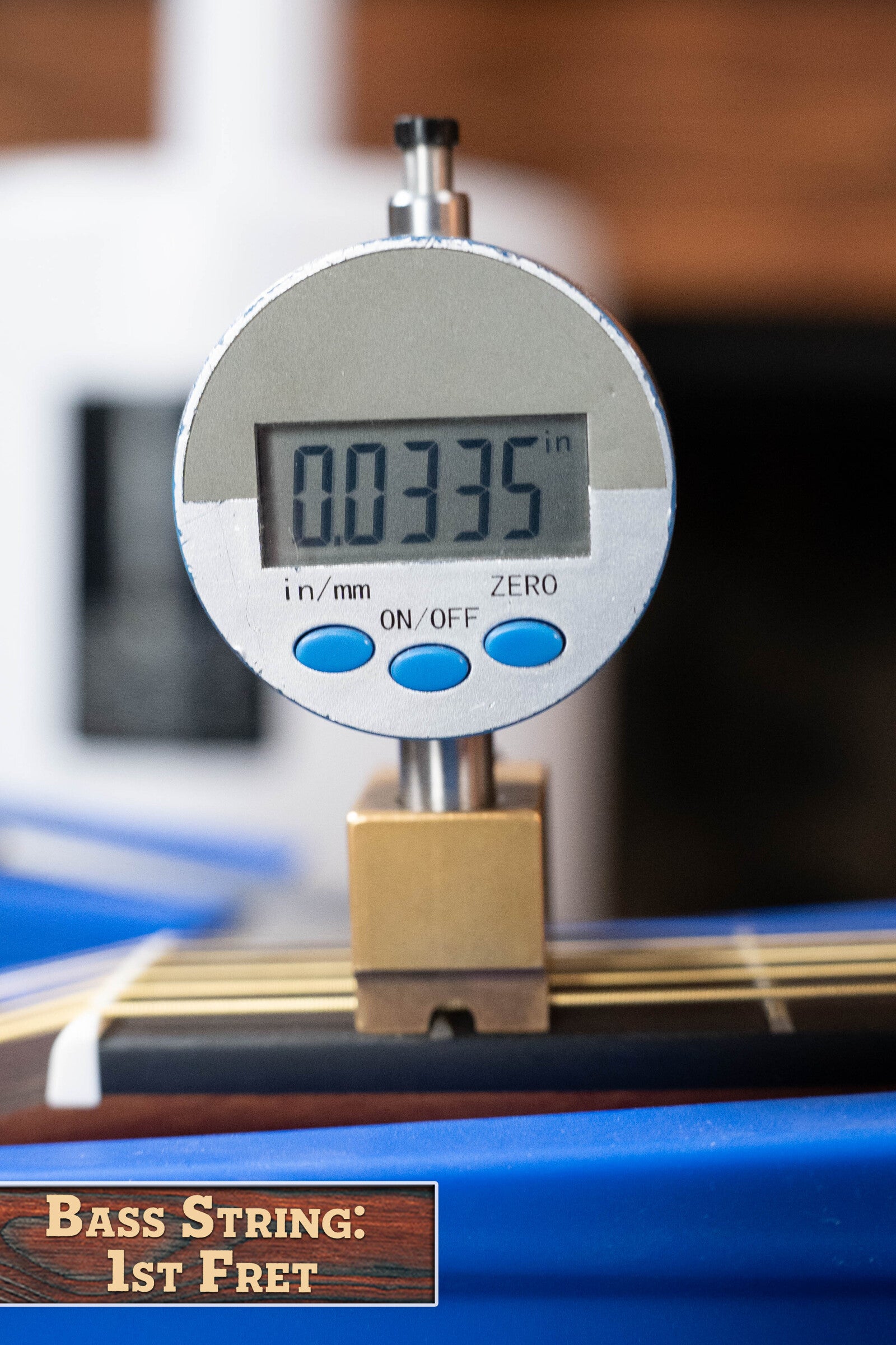 A close-up shows a digital gauge displaying 0.0335 in, measuring the string height at the 1st fret of a Yamaha GigMaker Deluxe Acoustic Pack - Natural Finish #8229 guitar. The label reads: Bass String: 1st Fret.