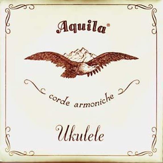 The Aquila Nylgut (7U) Concert Ukulele Strings packaging features a flying eagle, mountain backdrop, ornate borders, and brown Aquila corde armoniche Ukulele text on cream—emphasizing premium strings with accurate fret intonation.