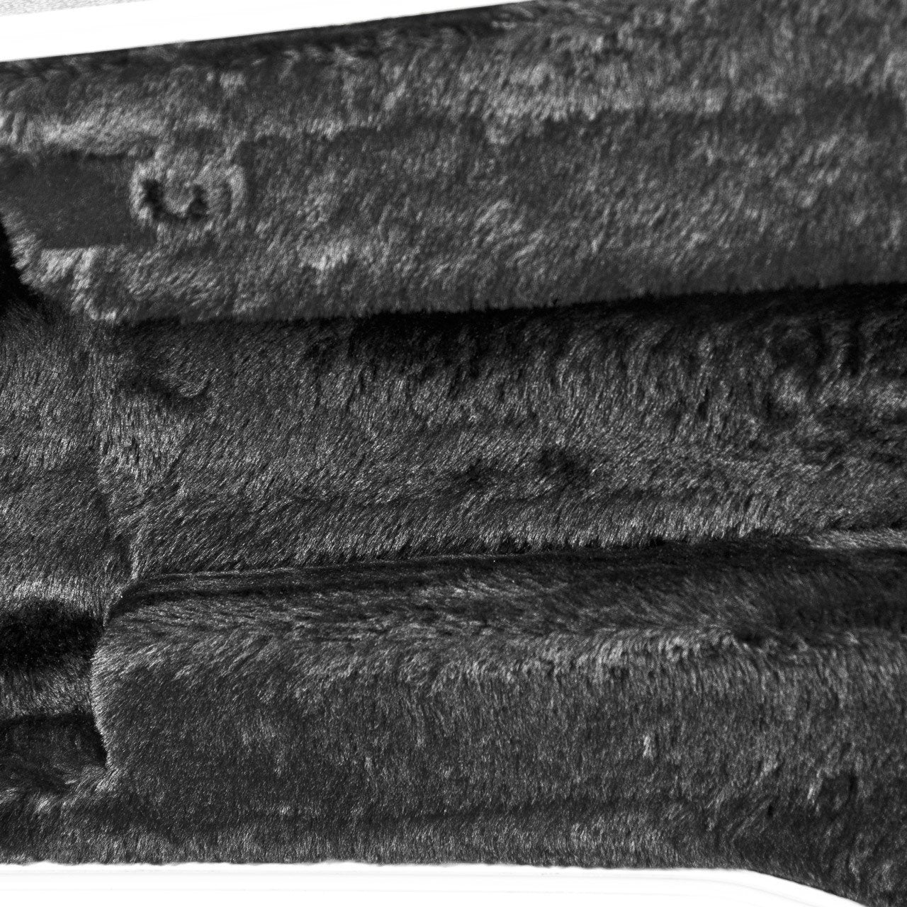 Close-up of the soft, dense, textured black lining in the Guardian CG-041-D ABS Case Dreadnought Guitar by Guardian, highlighting plush fibers, visible seams, and subtle surface variations.