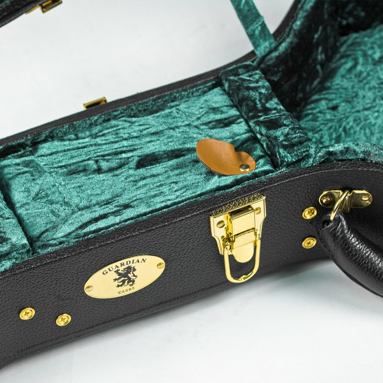 The Guardian CG-044-D Hardshell Case-Vintage Dreadnought by Guardian features an open black exterior with gold hardware, green crushed velvet lining, a tan leather pick holder inside, and plush padding for your acoustic guitar.