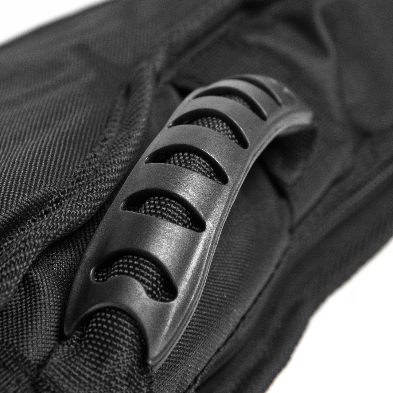 Close-up of the Guardian Elite Guitar Bag Dreadnought (CG-220-D) by Guardian, showing a sturdy, curved black plastic handle with cut-out slots for grip on the padded black gig bag.