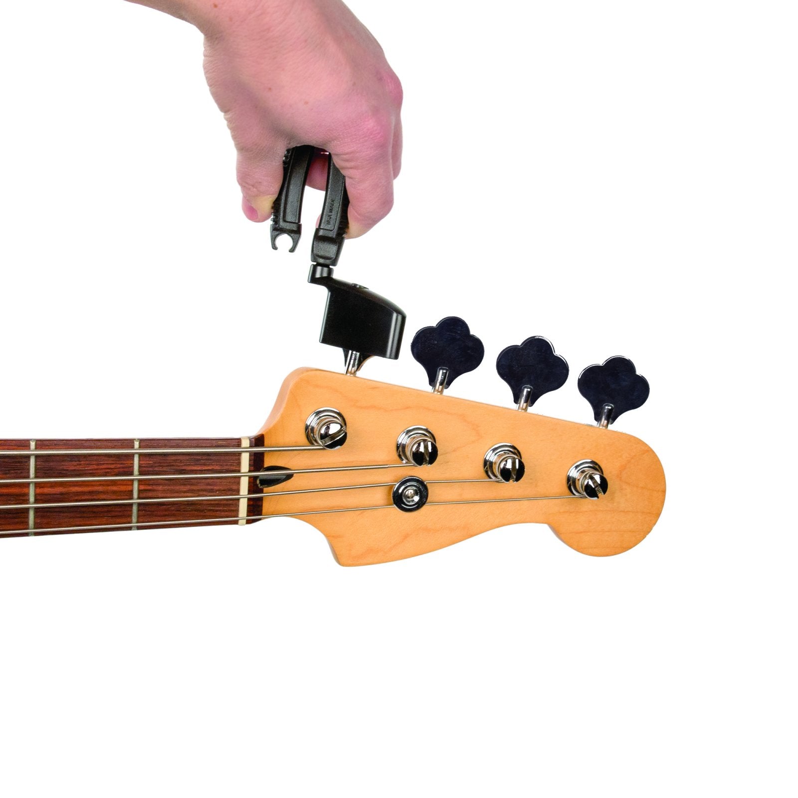 A hand uses the D'Addario Bass Pro-Winder String Winder and Cutter DP0002B on a bass guitar headstock with four tuning keys, making restringing fast and easy.