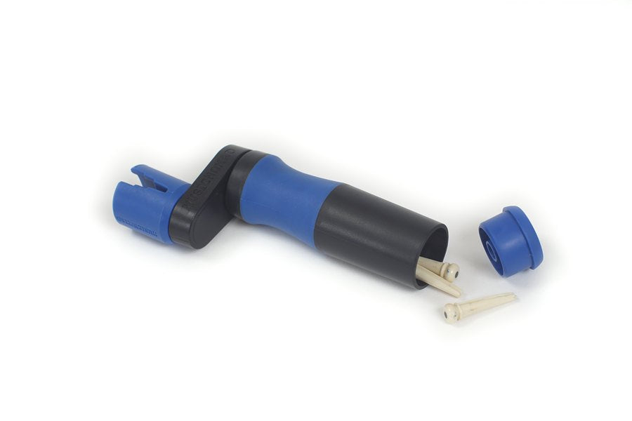 A blue and black golf tee holder, resembling the Music Nomad Grip Winder (MN221) by Music Nomad, sits open with wooden tees inside, while its cap and extra tees lie nearby.