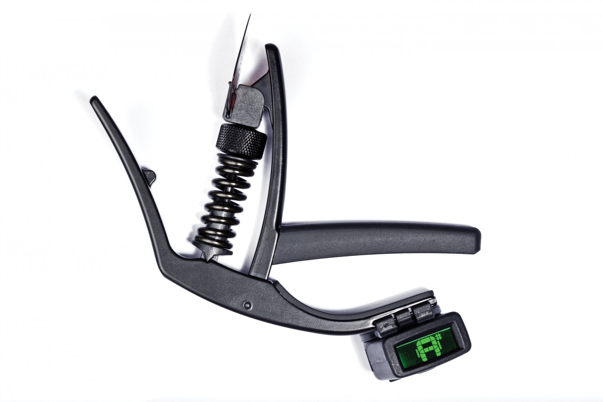 A DAddario/Planet Waves NS Artist Capo PW-CP-10 is shown on a white background, featuring a built-in digital tuner with an F displayed, a visible clamp spring, and micrometer tension adjustment for precise control.