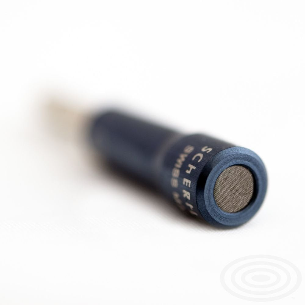 Close-up of a blue and black audio jack connector on a white surface, focused on the tip—perfect for connecting to the Schertler S-MIC-M Acoustic Guitar Magnetico AG6 Pickup Condenser for rich acoustic sound. The background blurs softly.