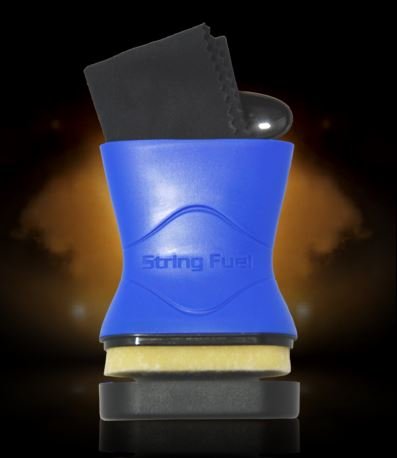 The Music Nomad String Fuel - Cleaner and Lubricant (MN109), a blue container with string cleaner, fretboard conditioner, cleaning cloth, and applicator, is displayed against a dark background with orange light effects.