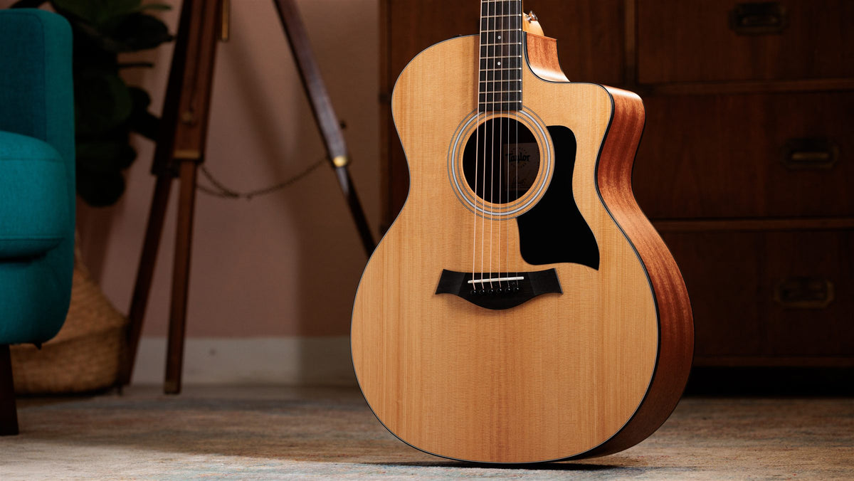 Taylor 100 Series lifestyle photo — guitar in a sunlit living room, The Acoustic Shoppe