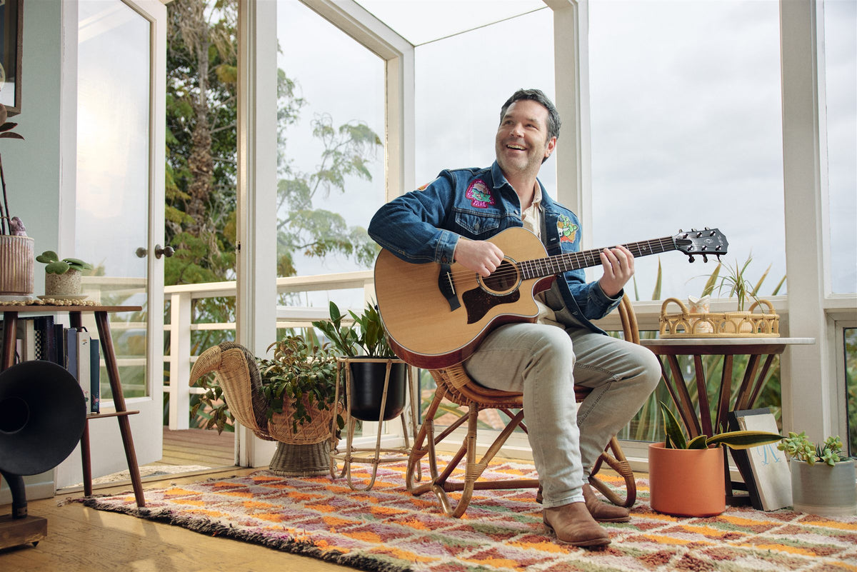 Taylor 500 Series lifestyle photo — musician playing a Taylor 514ce on a sunroom porch, The Acoustic Shoppe