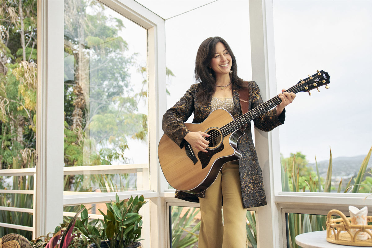 Taylor 700 Series lifestyle photo — musician playing a Taylor 714ce on a sunroom porch, The Acoustic Shoppe